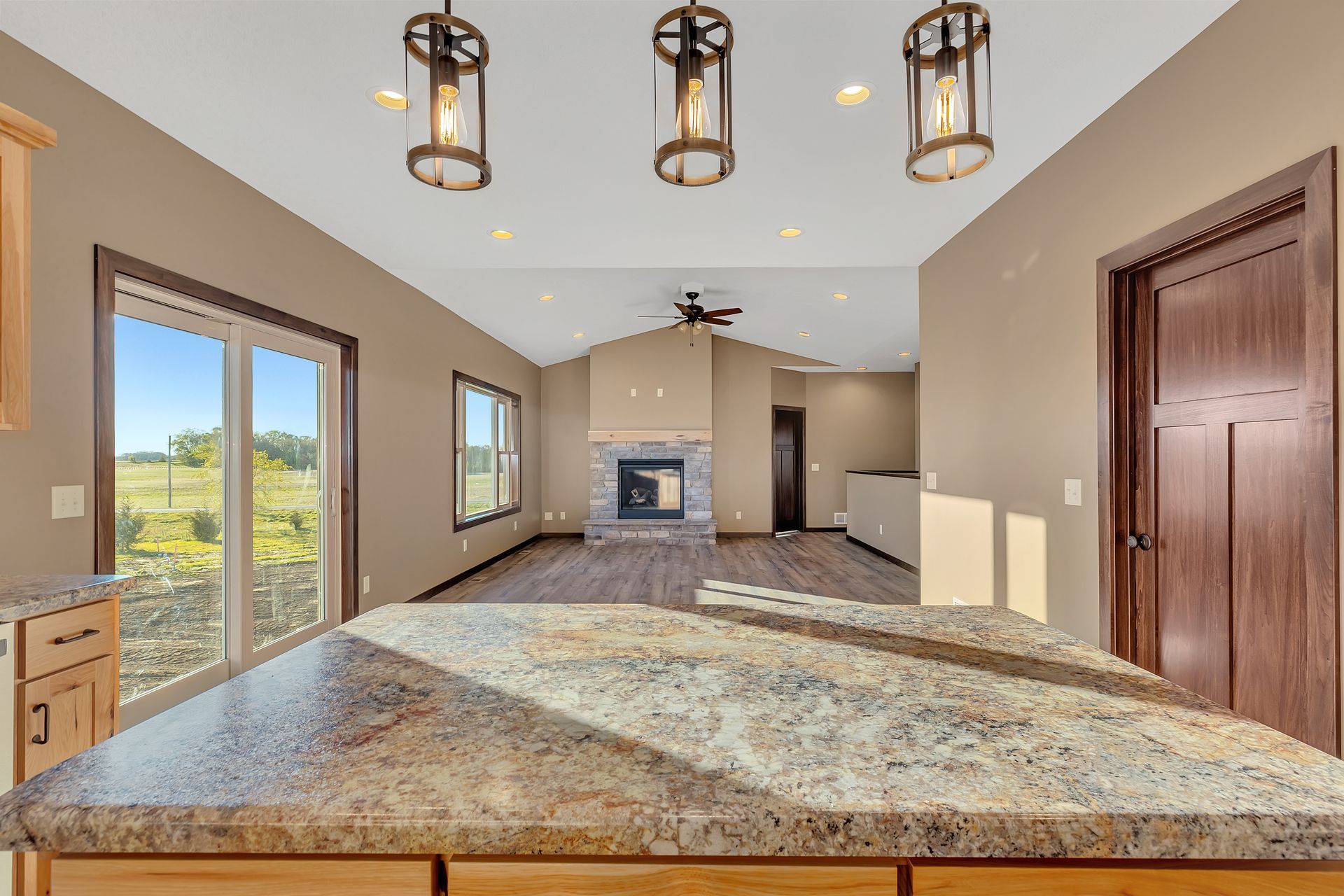 A kitchen with a granite counter top and a fireplace.