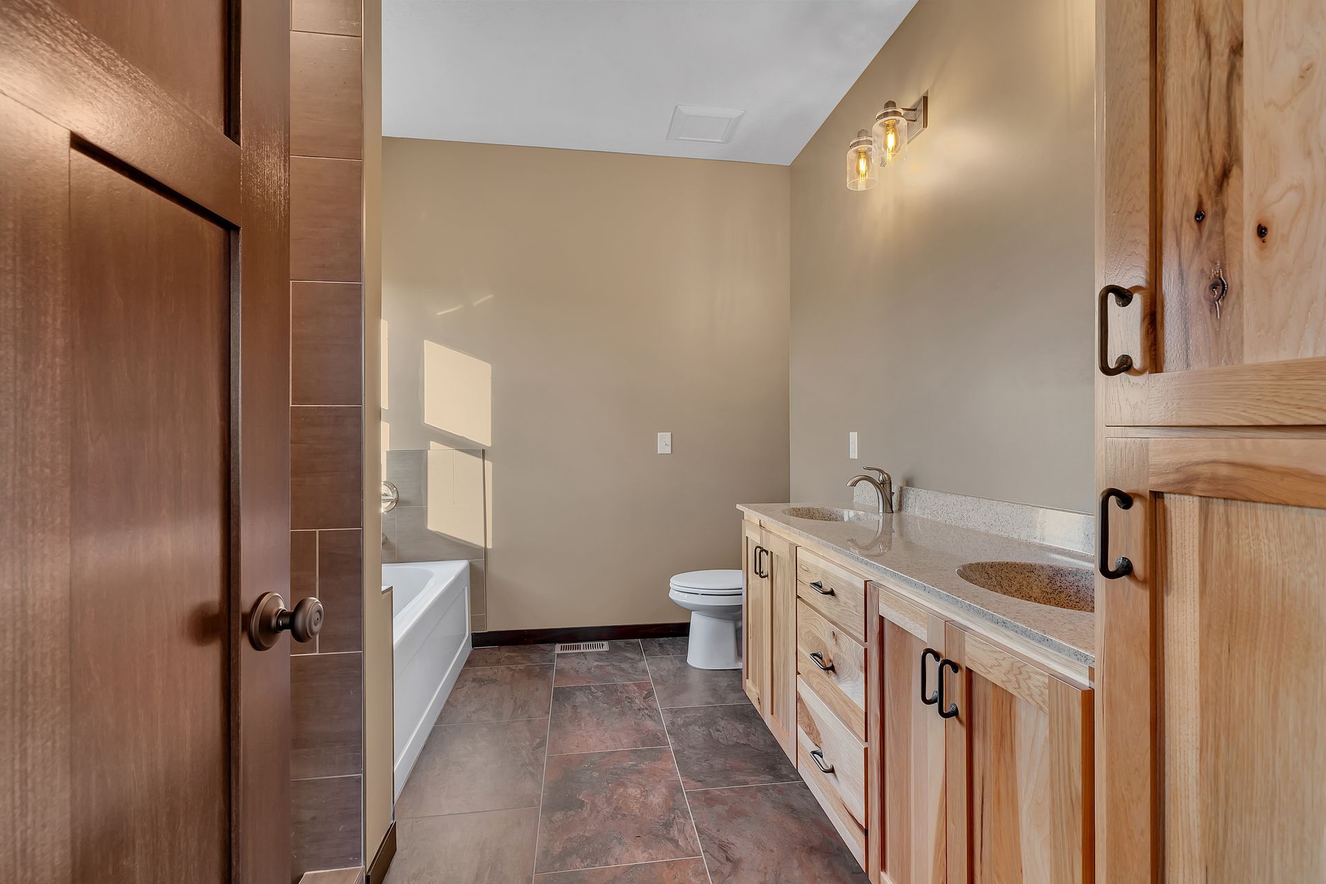 A bathroom with two sinks , a toilet , and a bathtub.