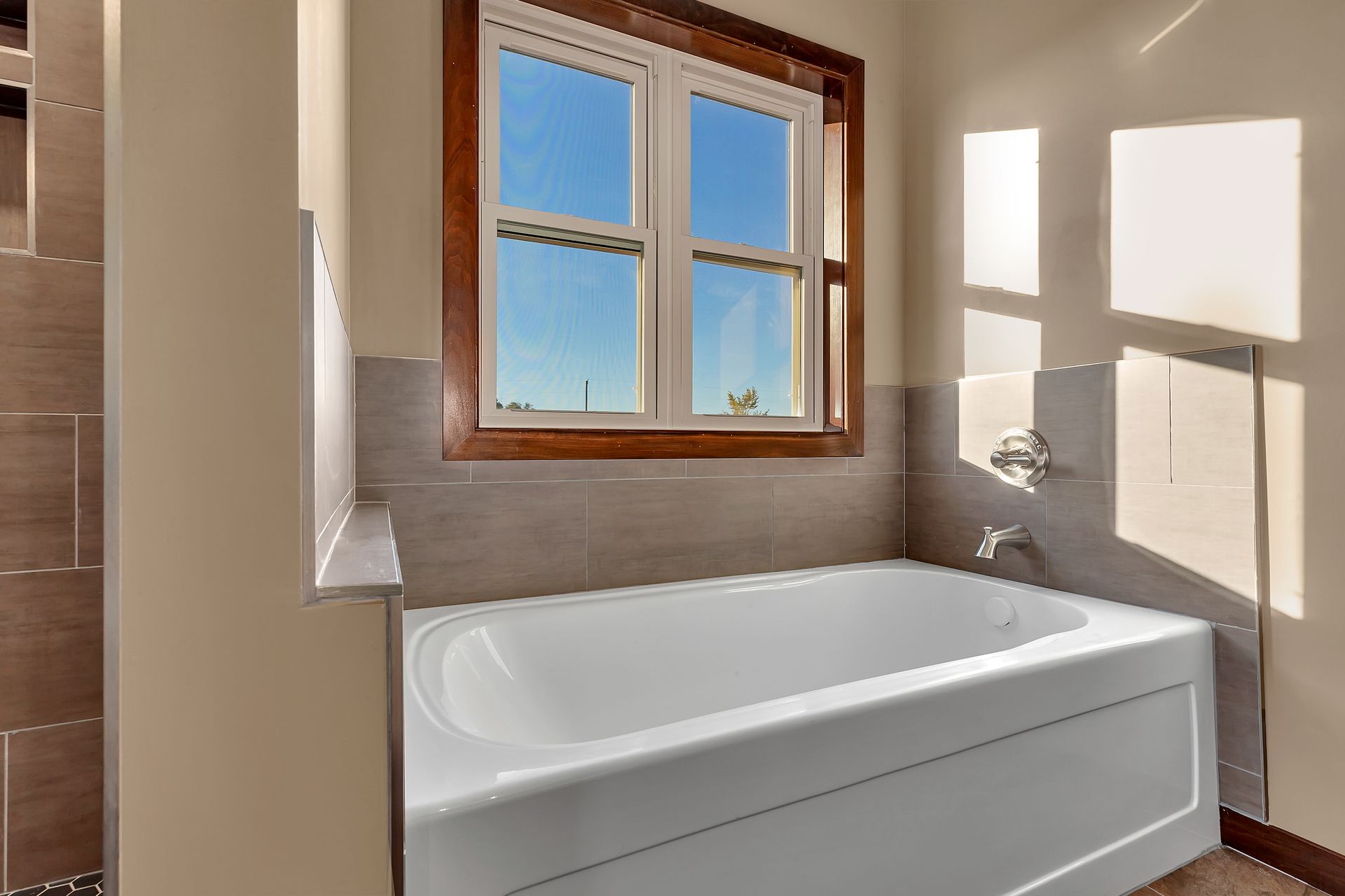 A bathroom with a bathtub and a window.