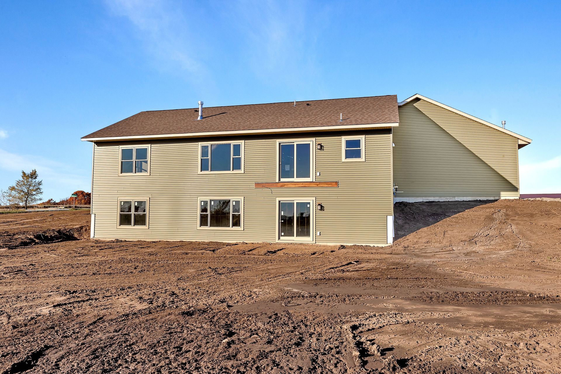 A house is sitting in the middle of a dirt field