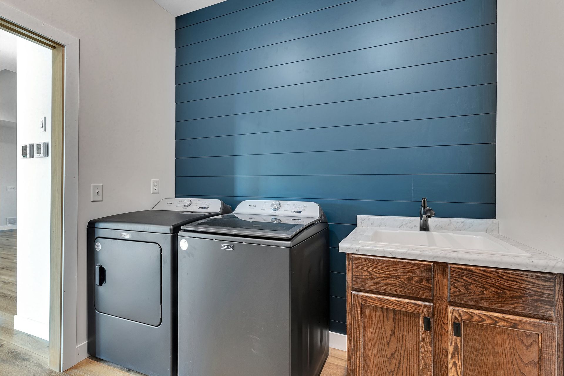 A laundry room with a washer and dryer and a sink.