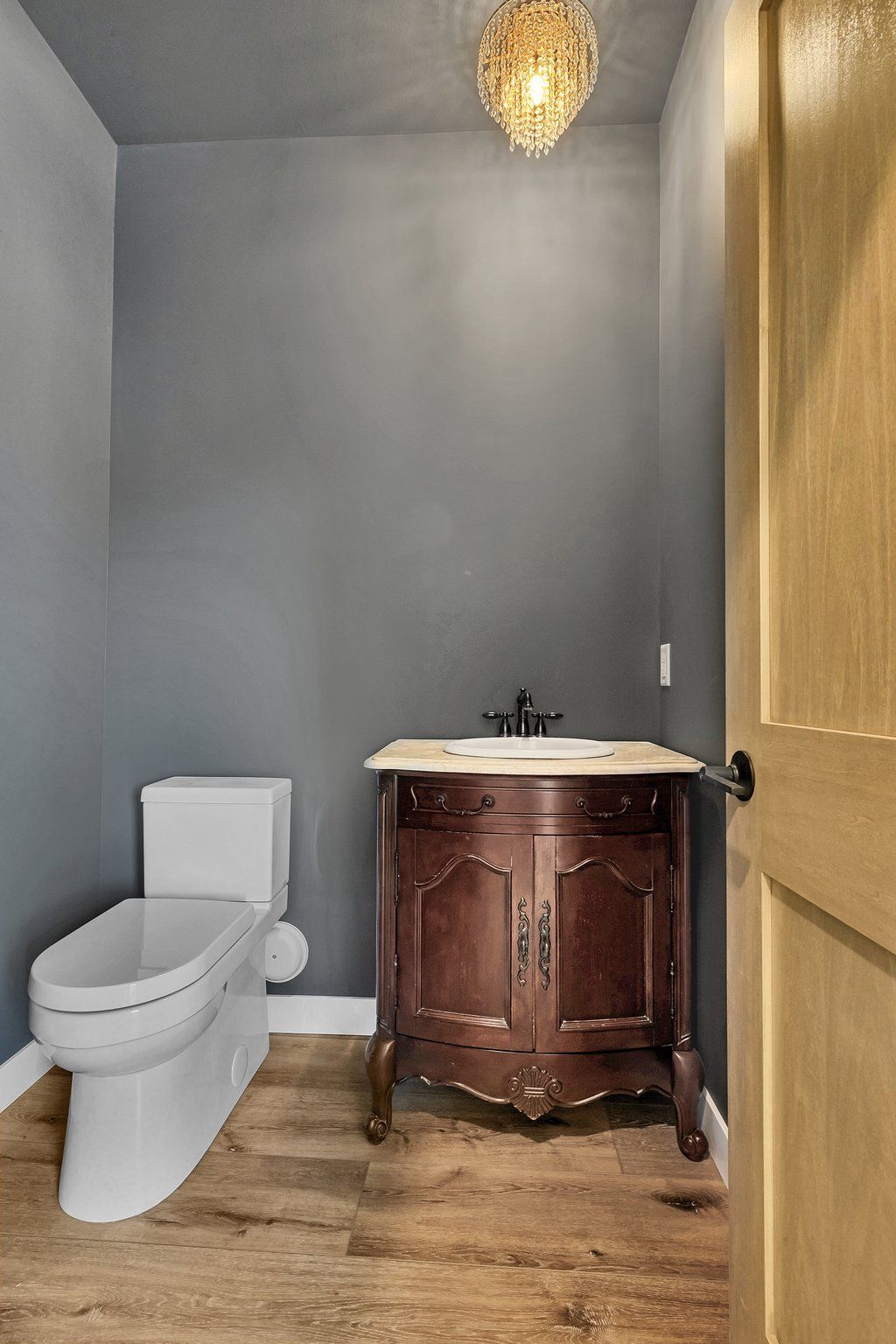 A bathroom with a toilet , sink and cabinet