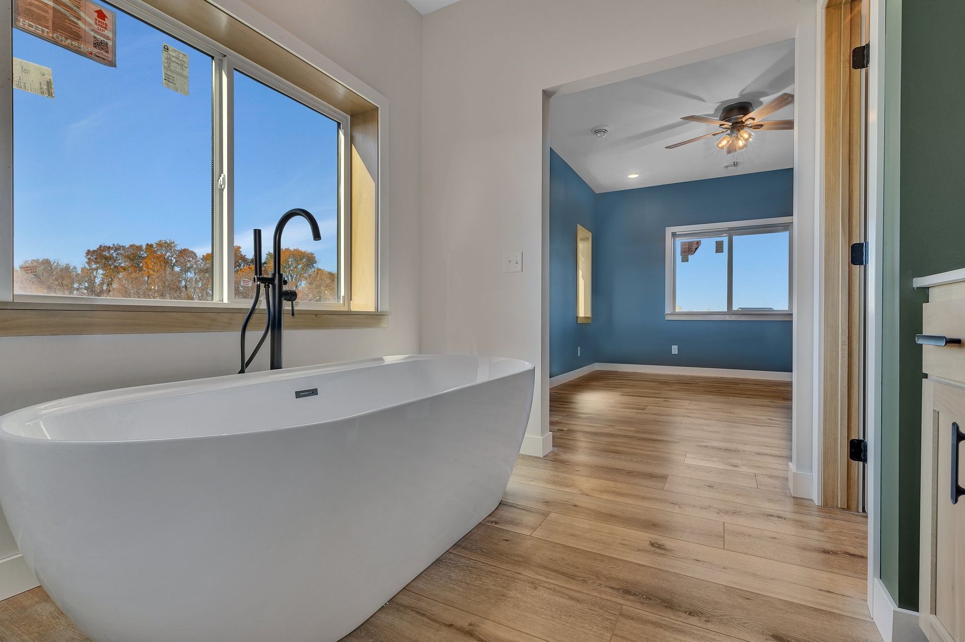 A bathroom with a bathtub and a ceiling fan.