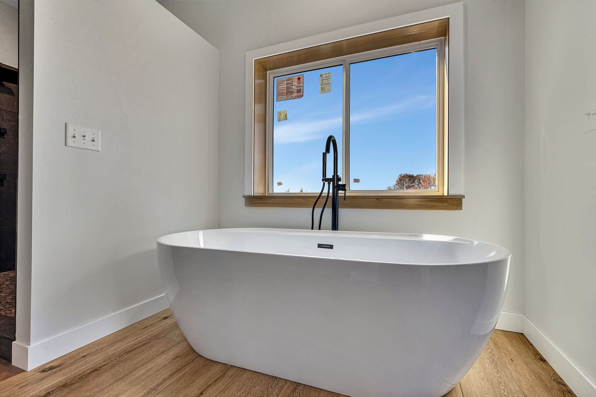 A bathtub is sitting in a bathroom next to a window.