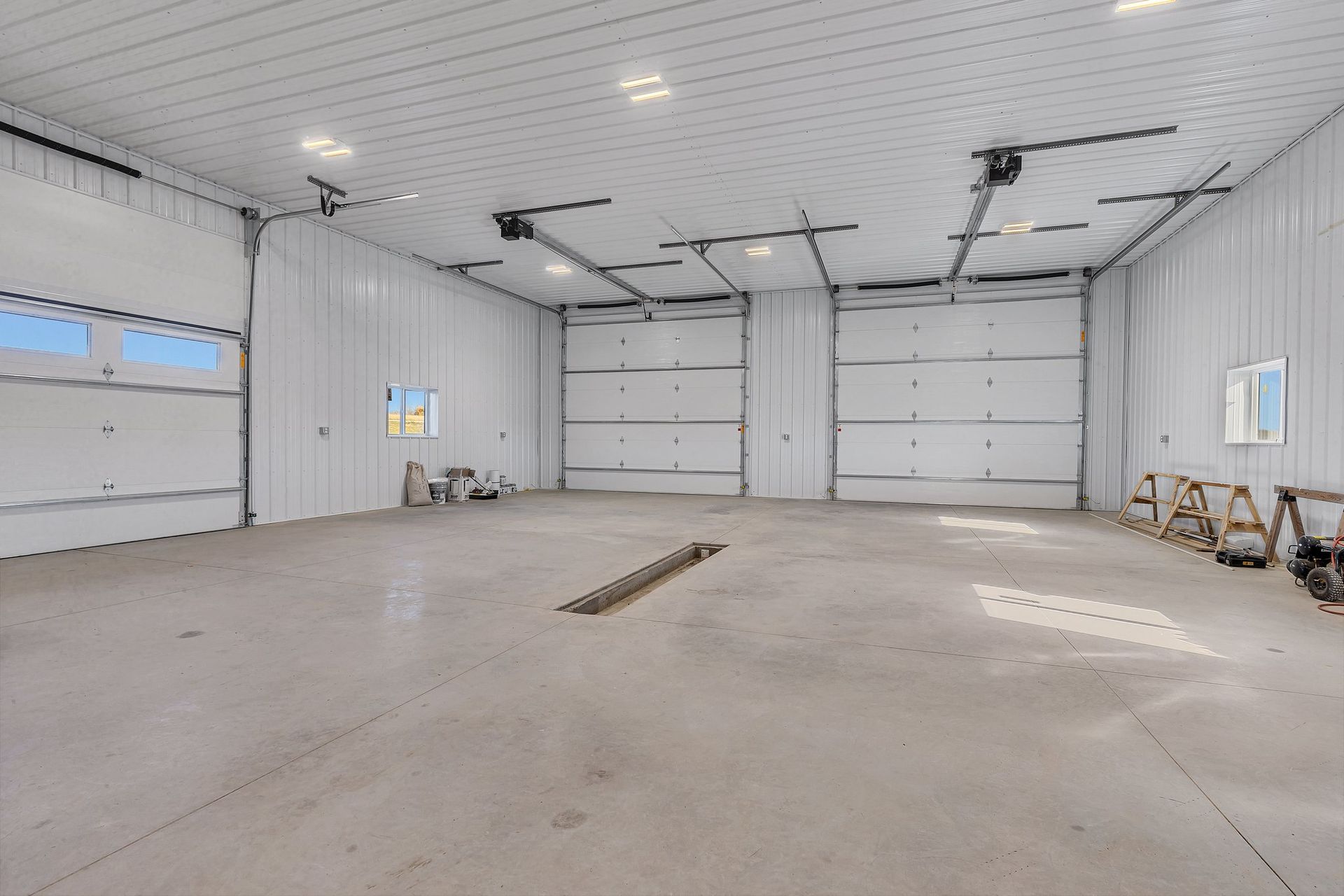 A large empty garage with a lot of doors and windows.