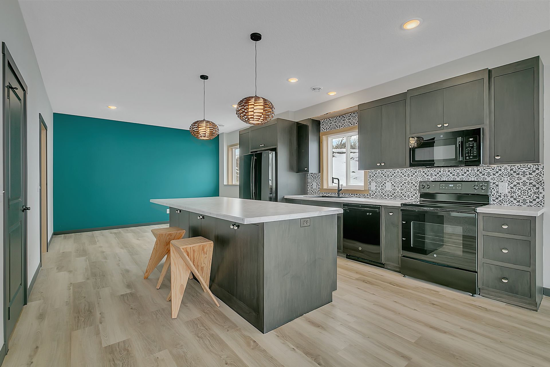 A kitchen with a large island and a blue wall.