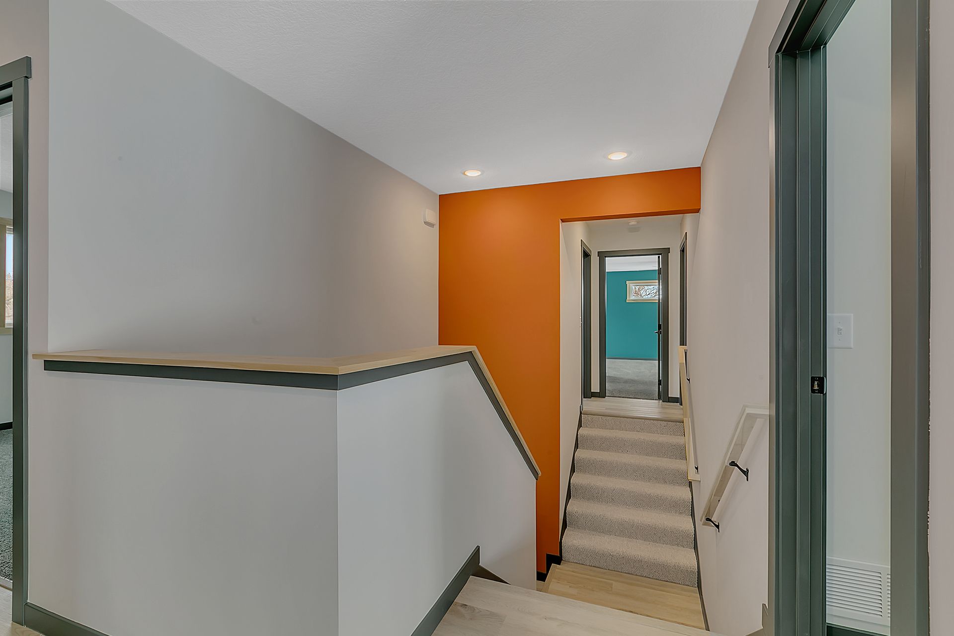 A hallway with stairs leading up to the second floor of a building.