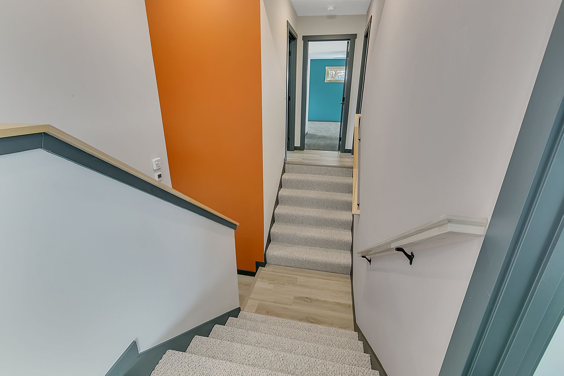 A hallway with stairs leading up to the second floor of a house.