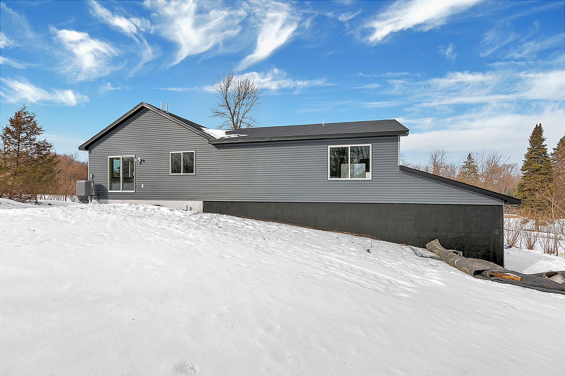 A house is sitting on top of a snow covered hill.