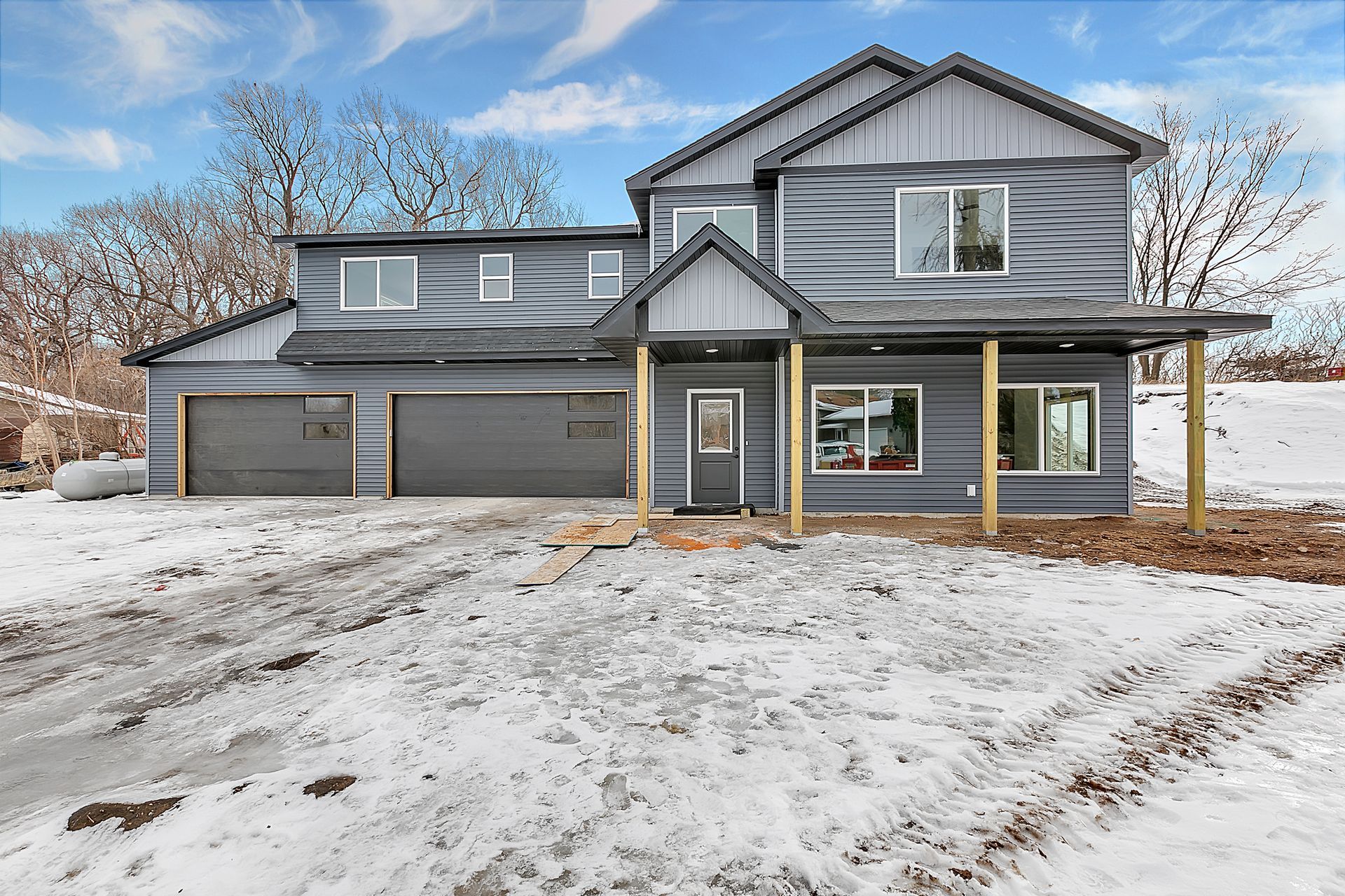 A large house is sitting in the middle of a snowy field.