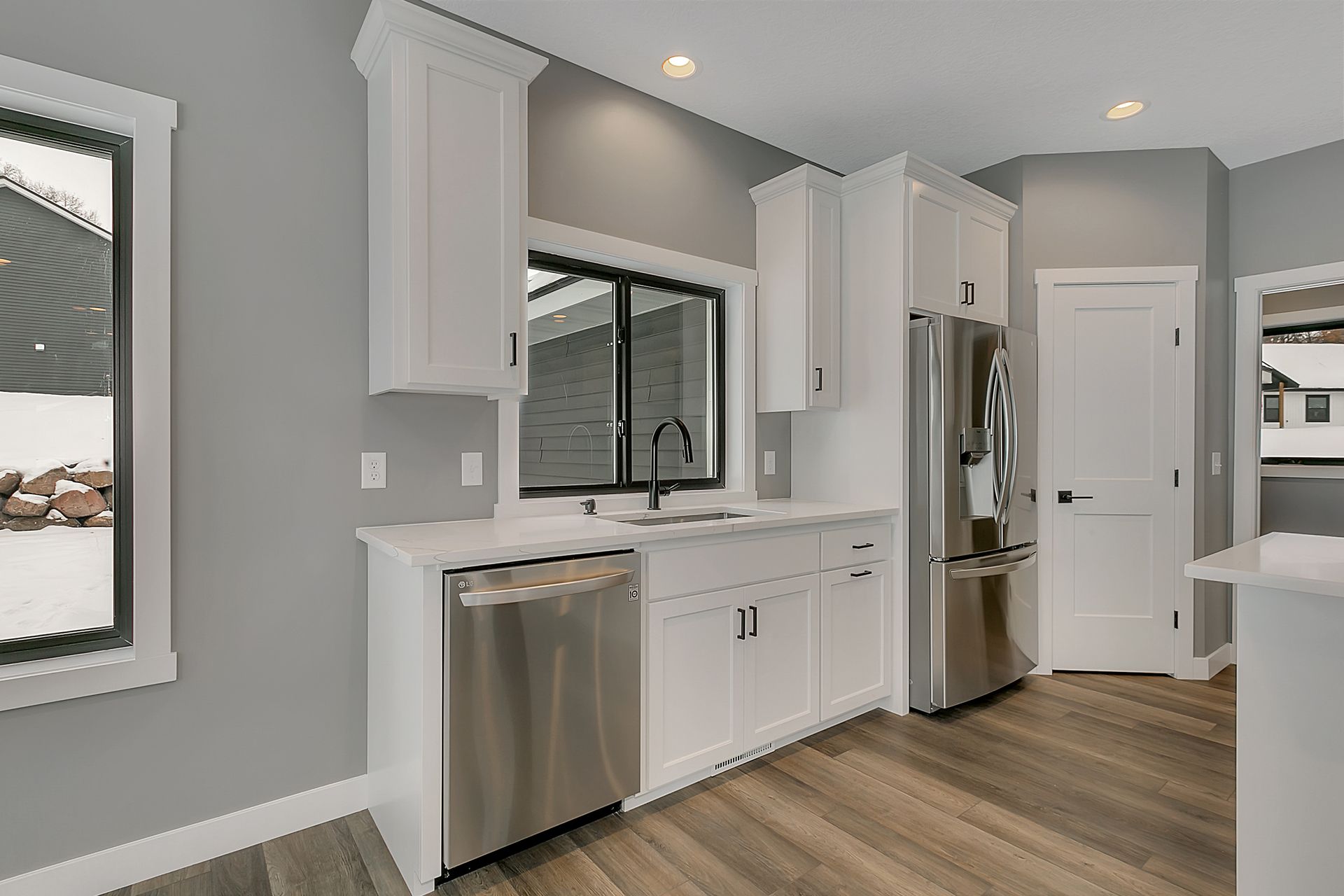 A kitchen with white cabinets and stainless steel appliances.