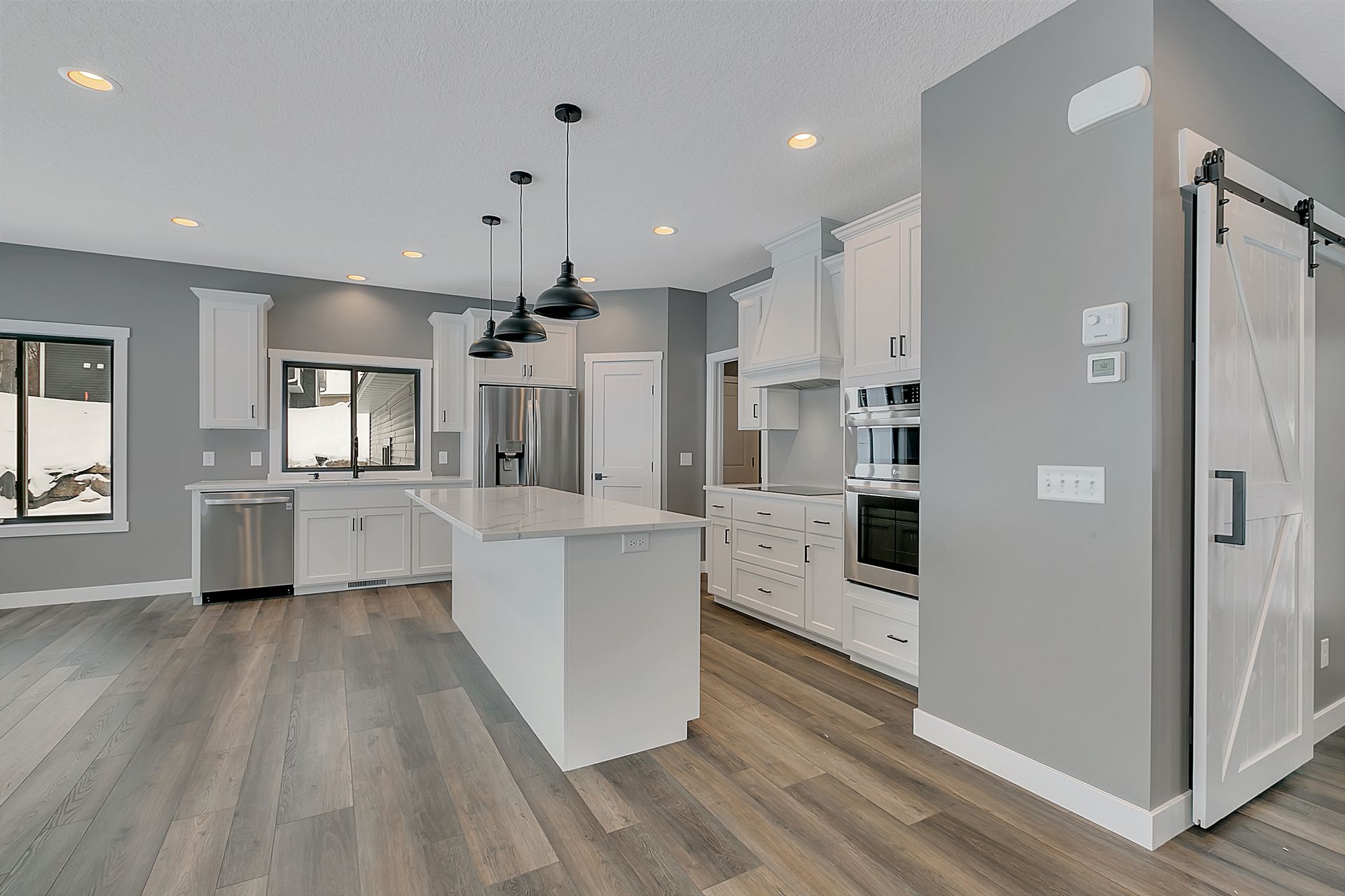 A kitchen with a large island and a sliding barn door.