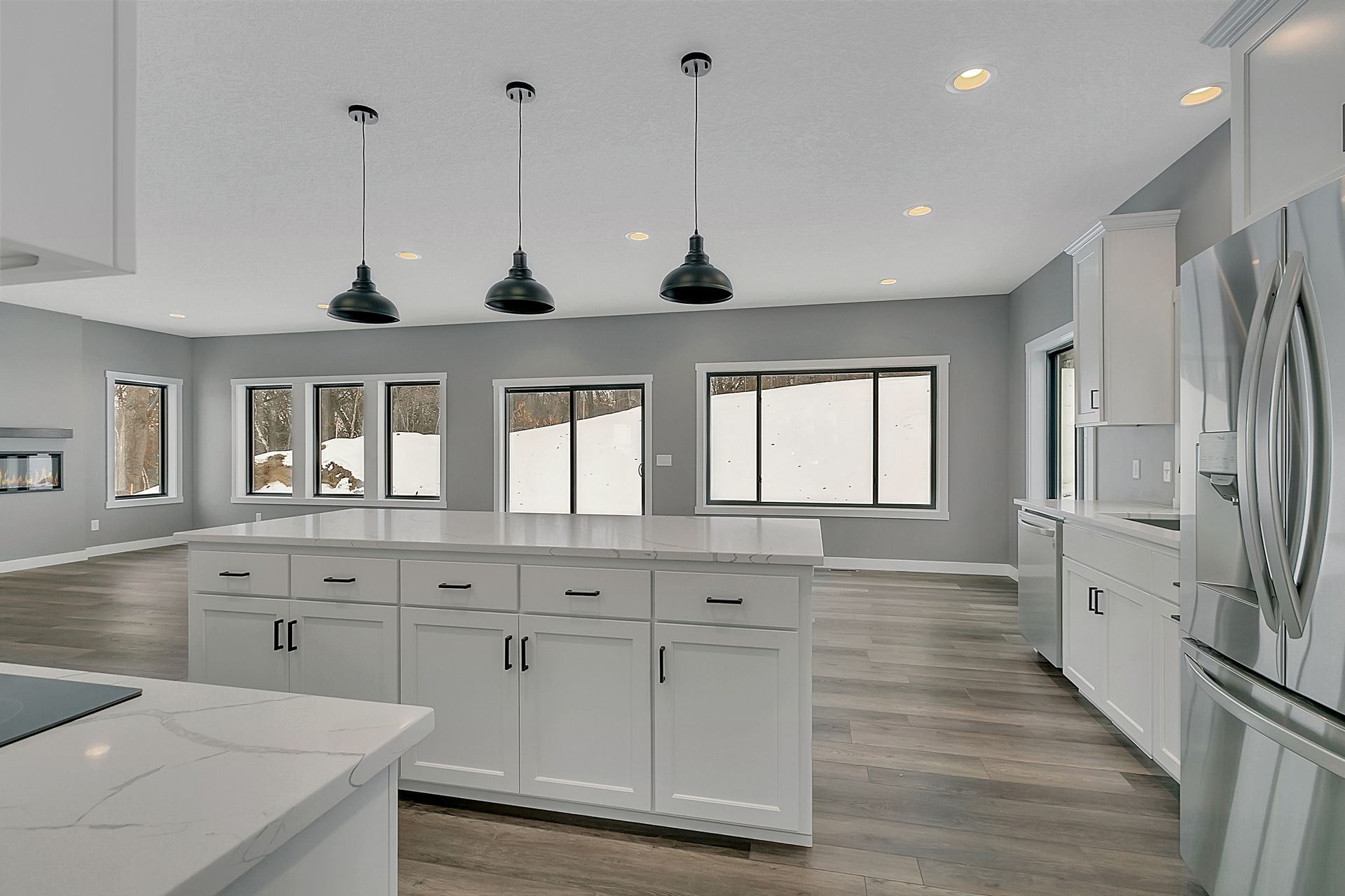 A kitchen with white cabinets and a large island in the middle