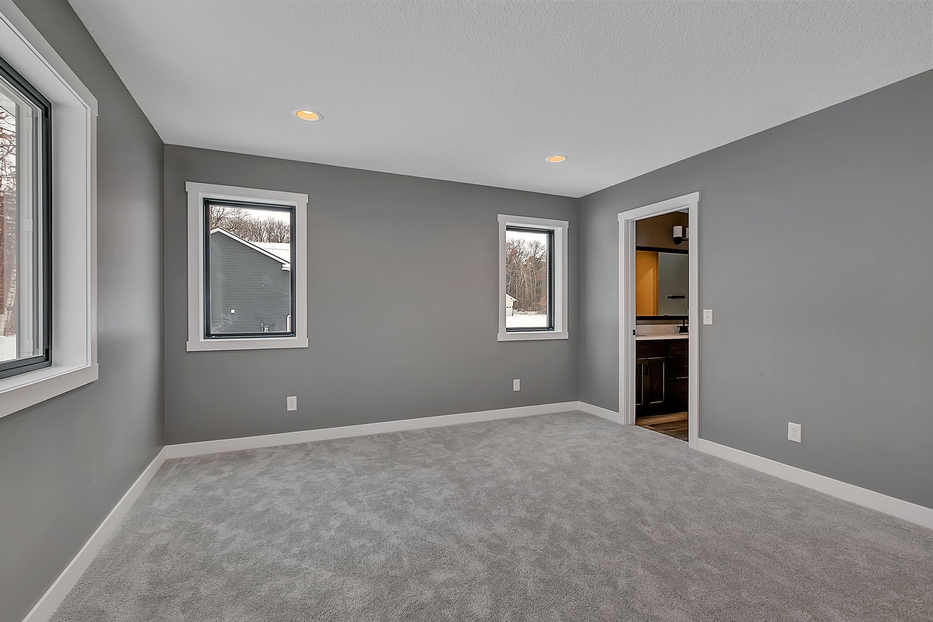 An empty room with gray walls and a carpeted floor.