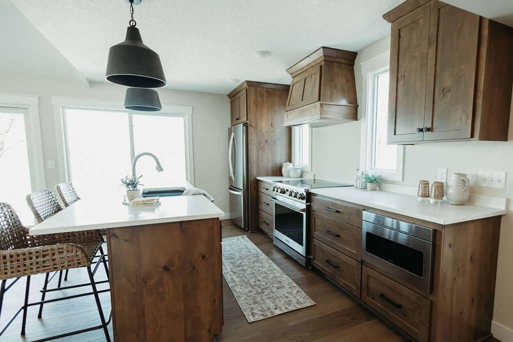 Modern kitchen with wooden cabinets, island, pendant light, and large windows