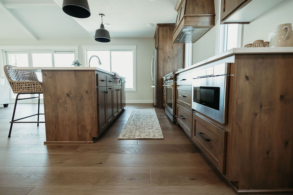 Modern kitchen with wood cabinets, island, pendant lights, and hardwood floors