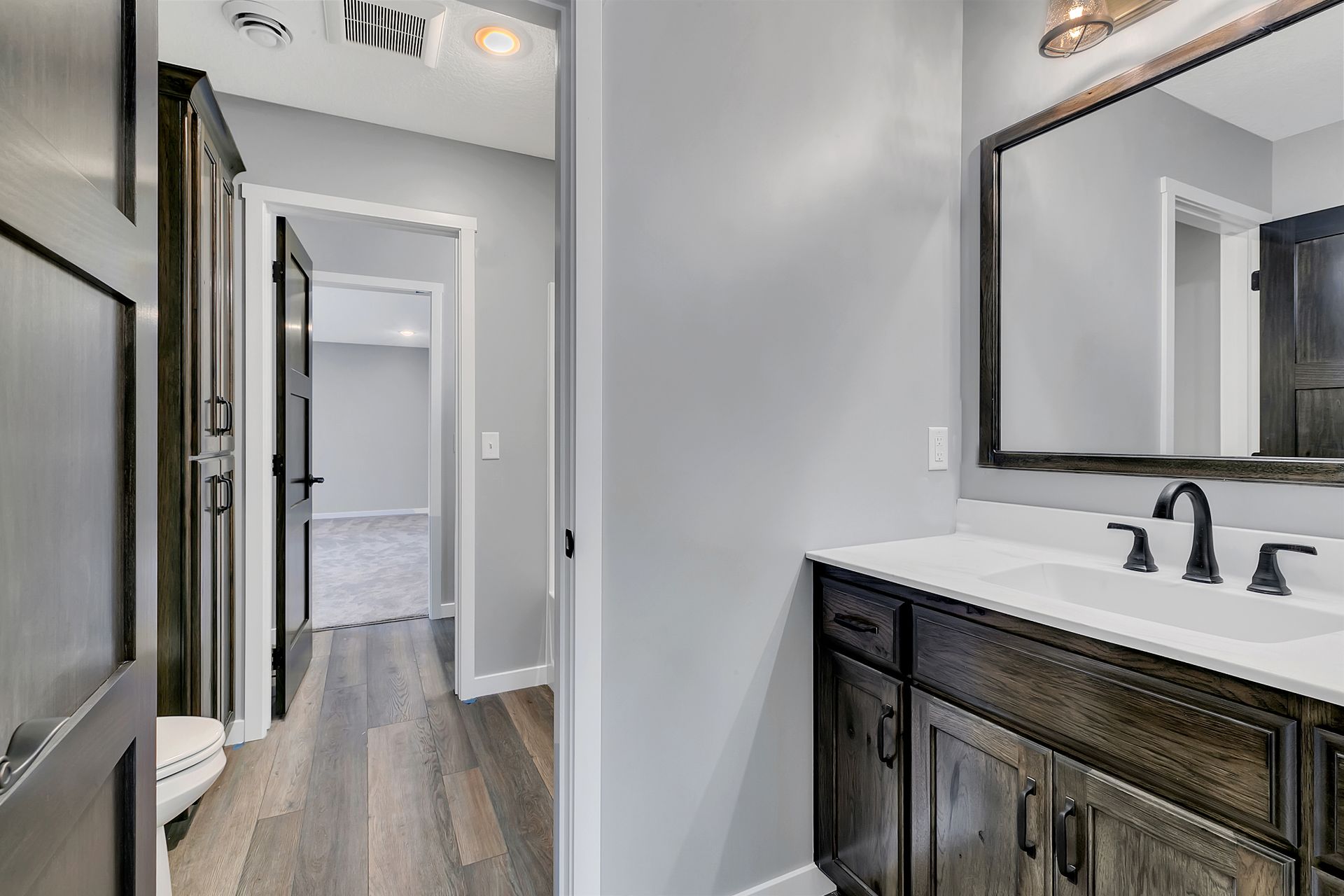 A bathroom with a sink , mirror and toilet.