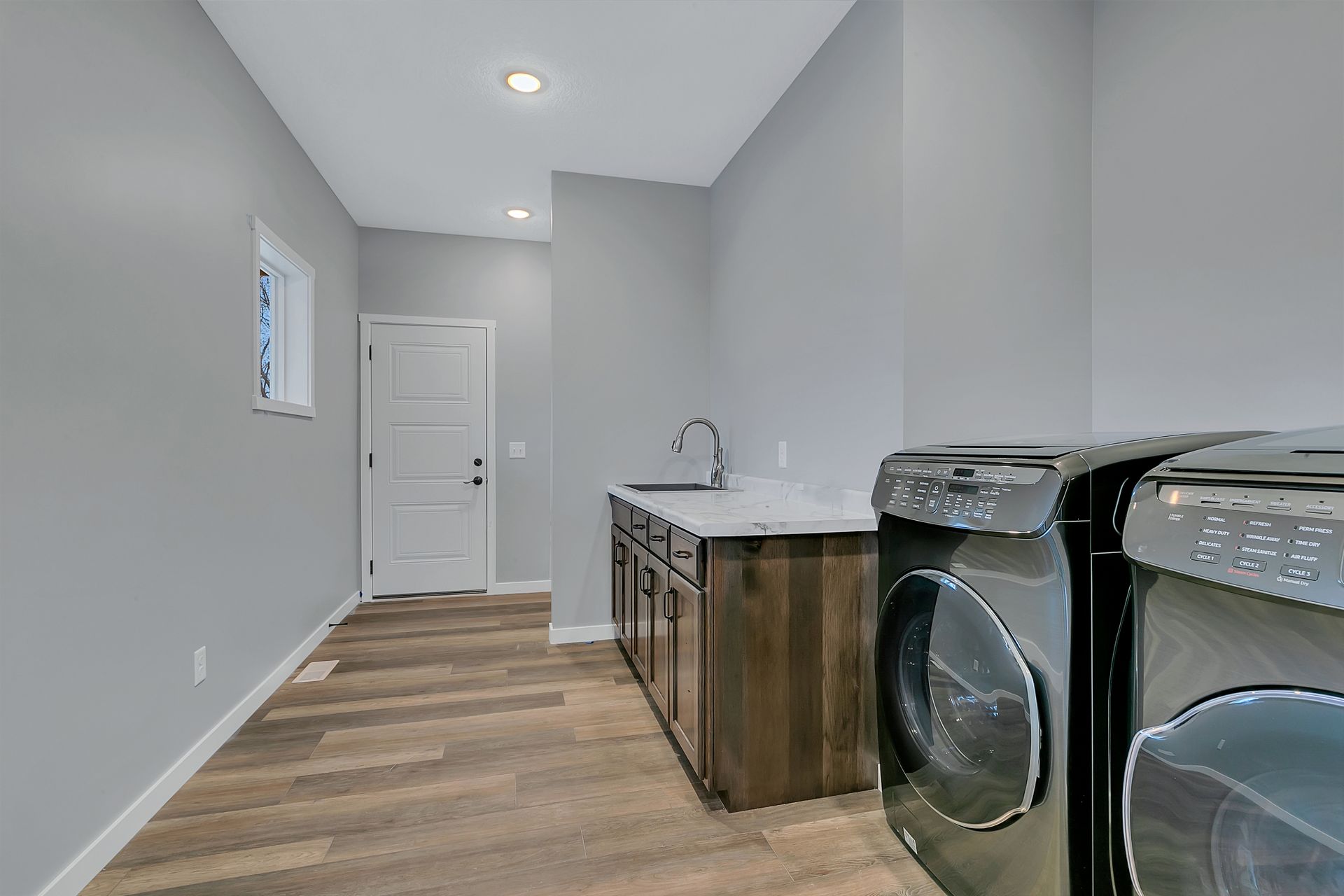 A laundry room with a washer and dryer and a sink.