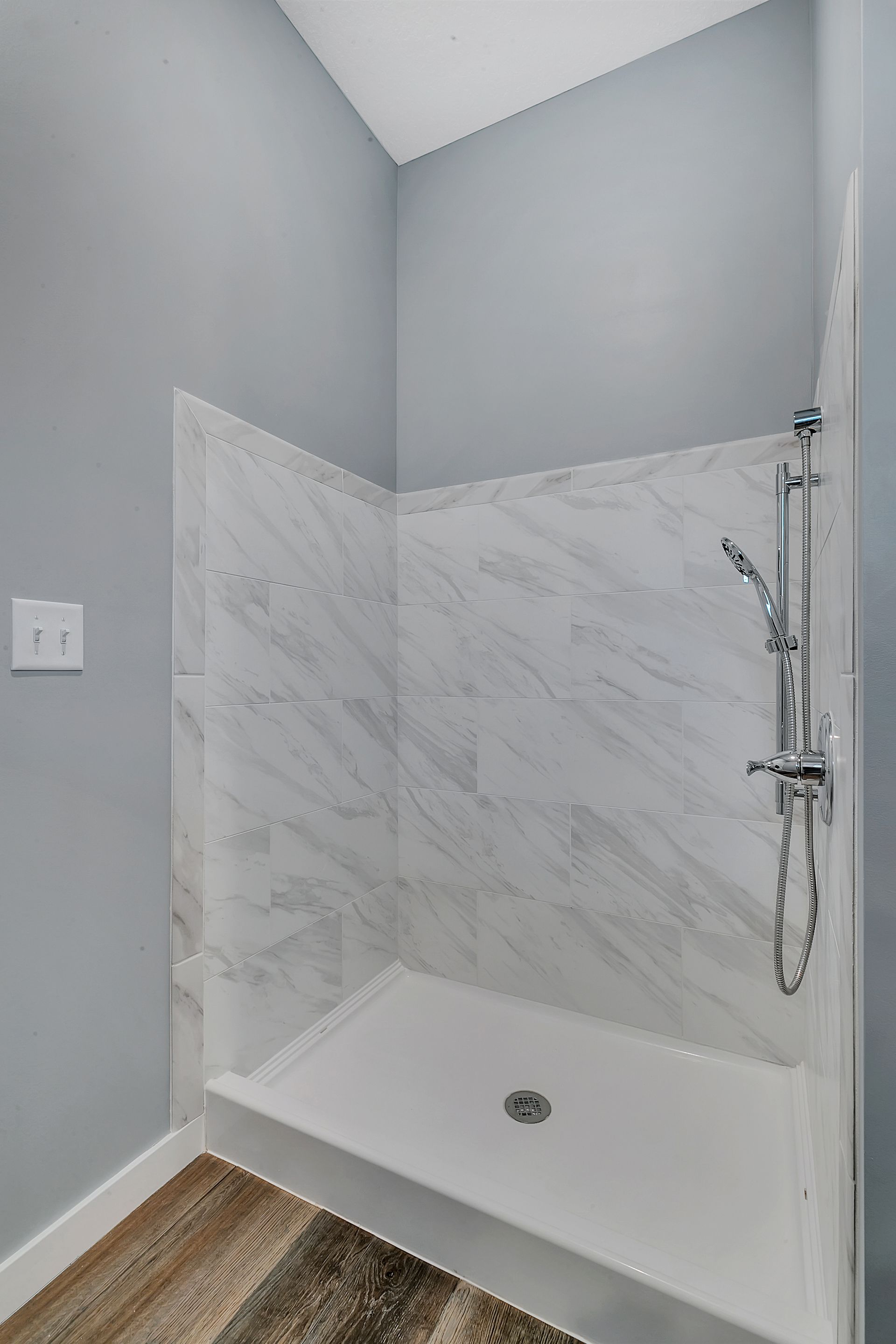 A bathroom with a walk in shower and a shower head.