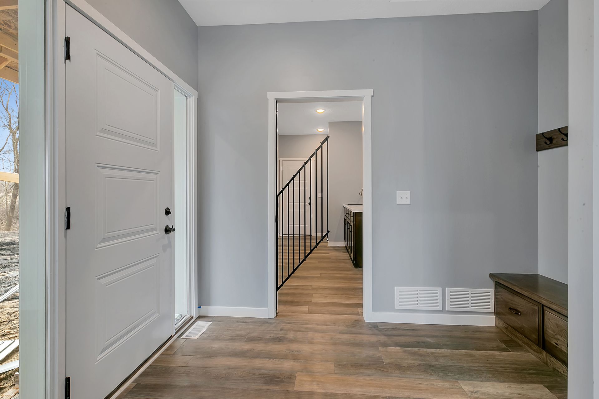 A hallway with a staircase leading up to the second floor of a house.