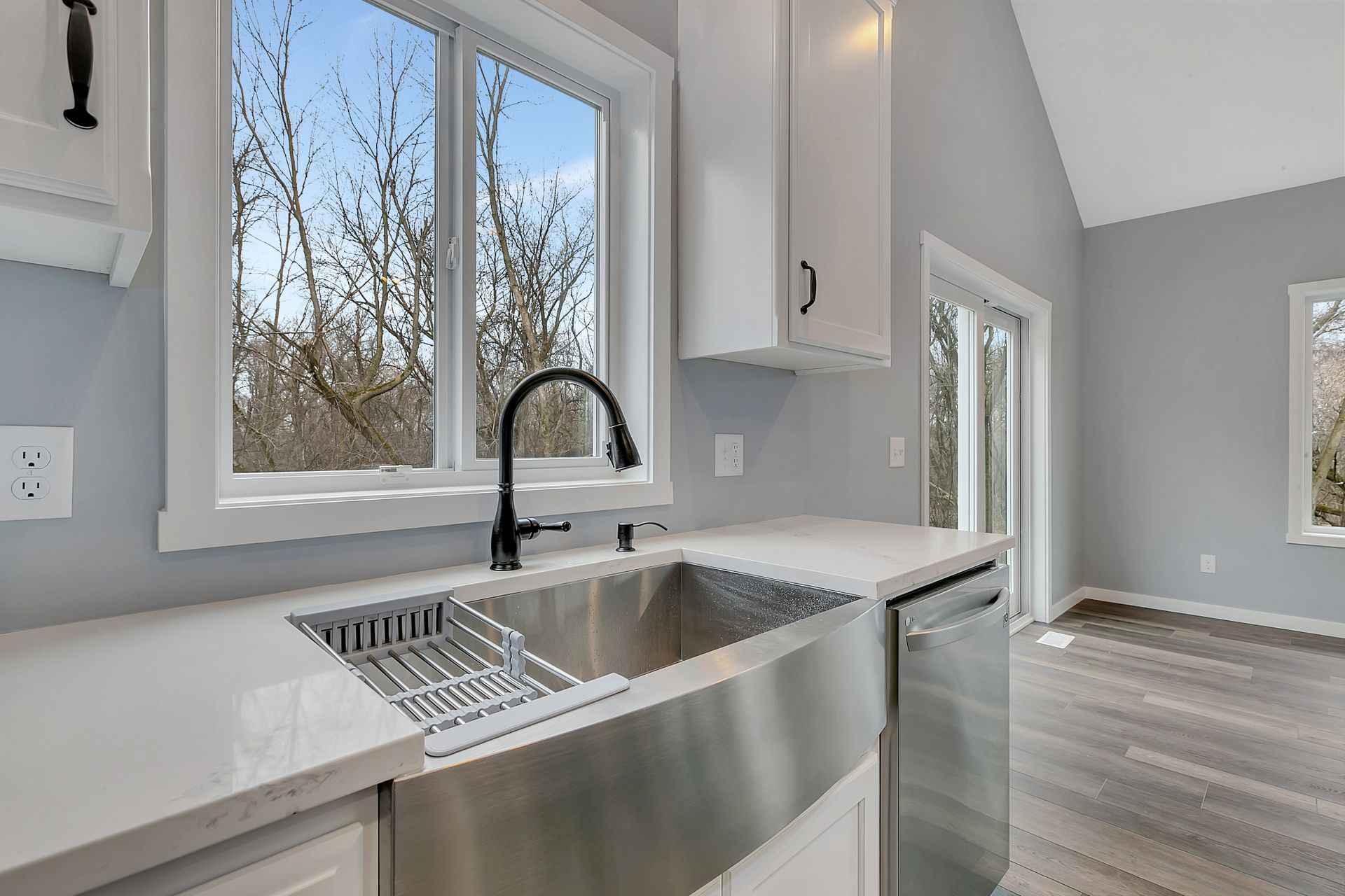 A kitchen with a stainless steel sink and a window.