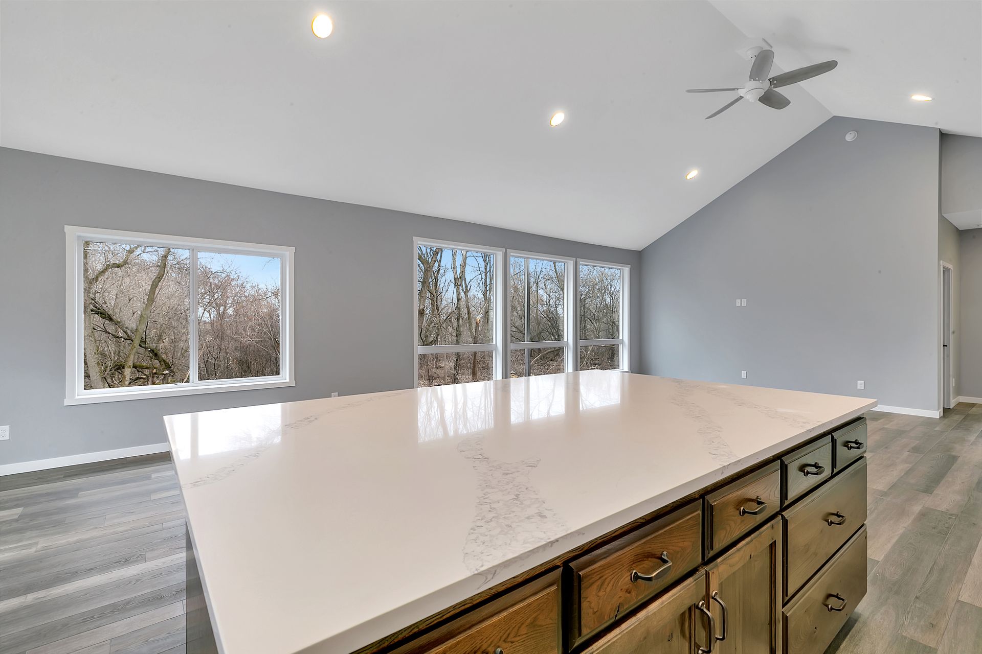 A kitchen with a large island and a ceiling fan.