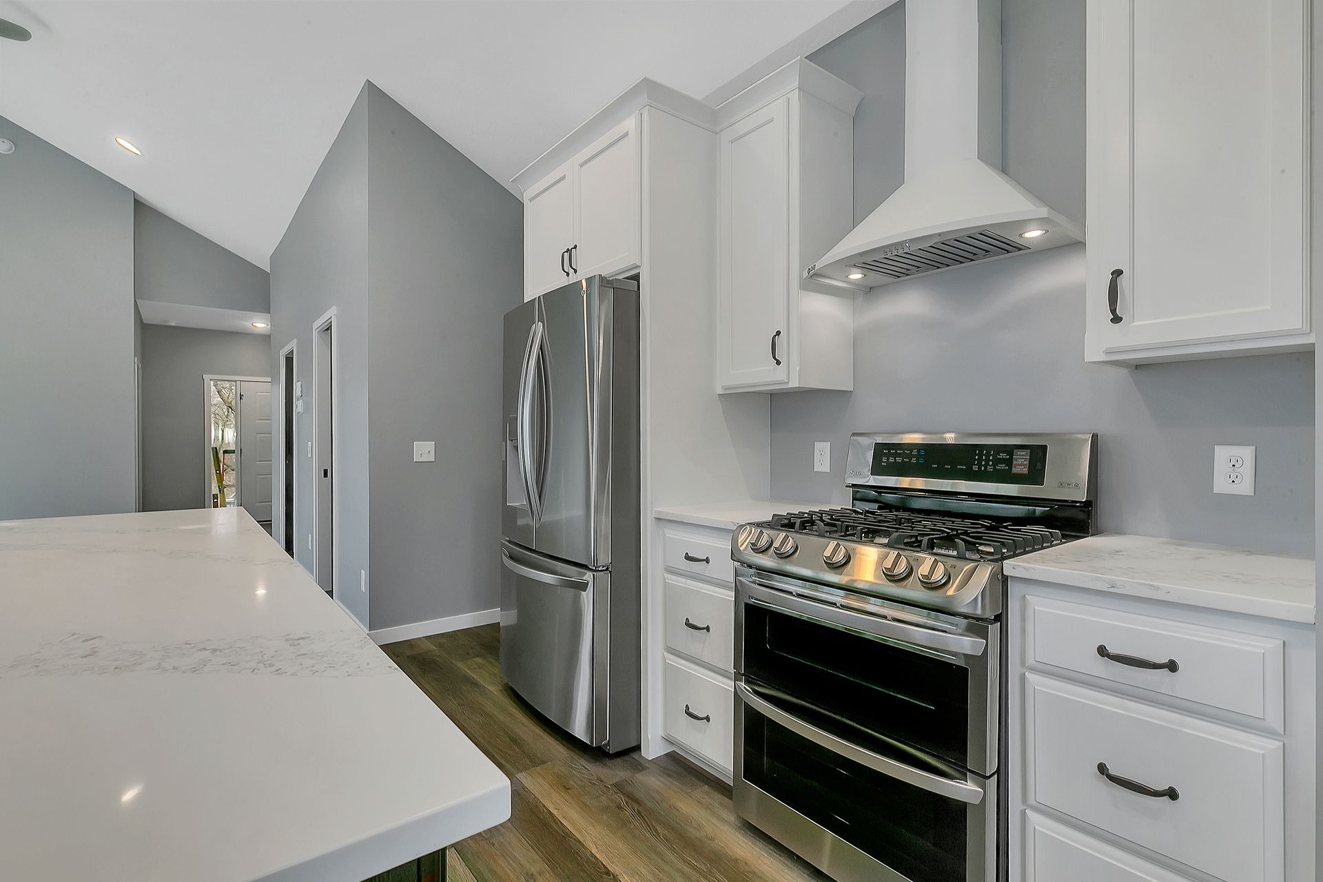 A kitchen with stainless steel appliances and white cabinets.