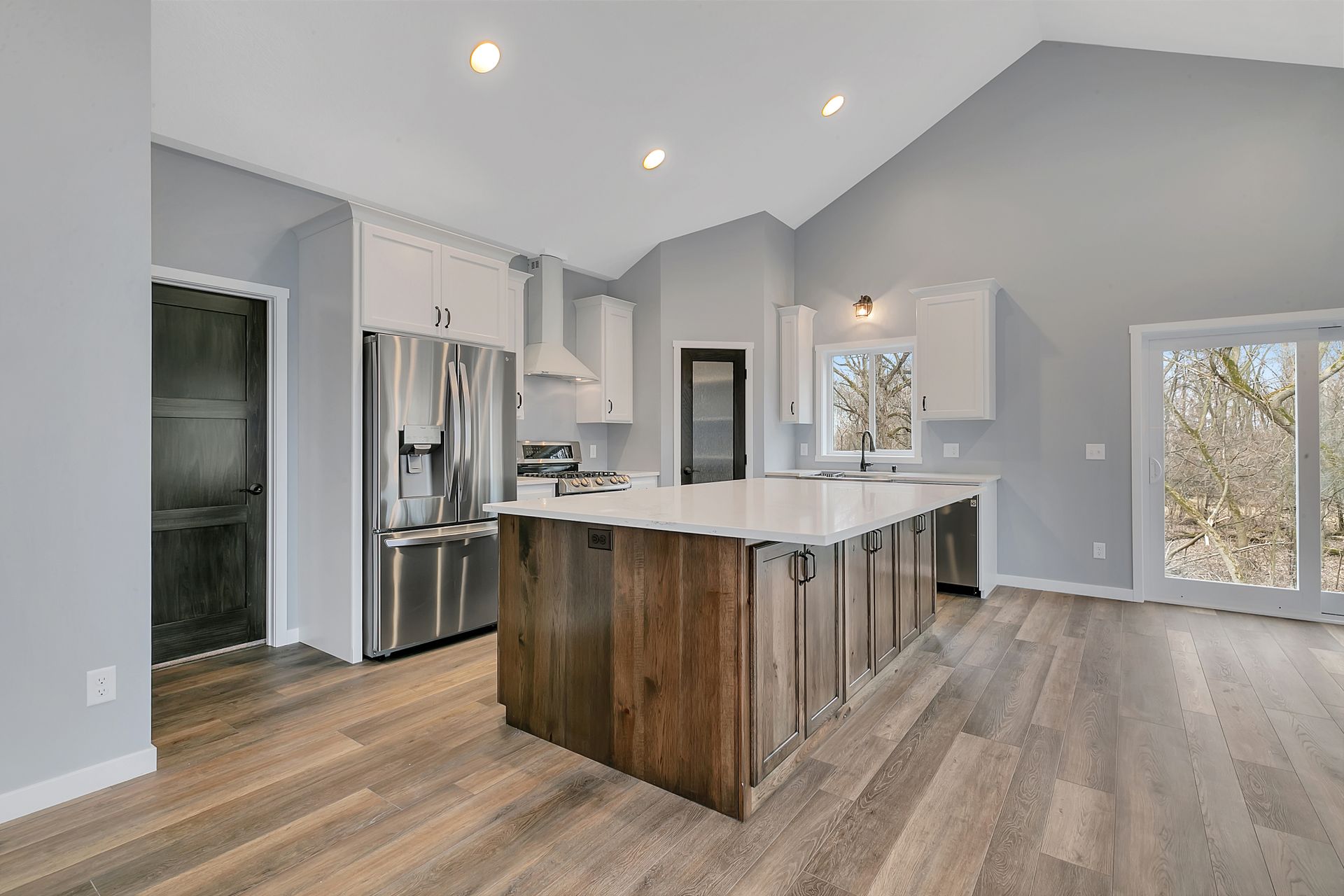 A kitchen with a large island and stainless steel appliances.
