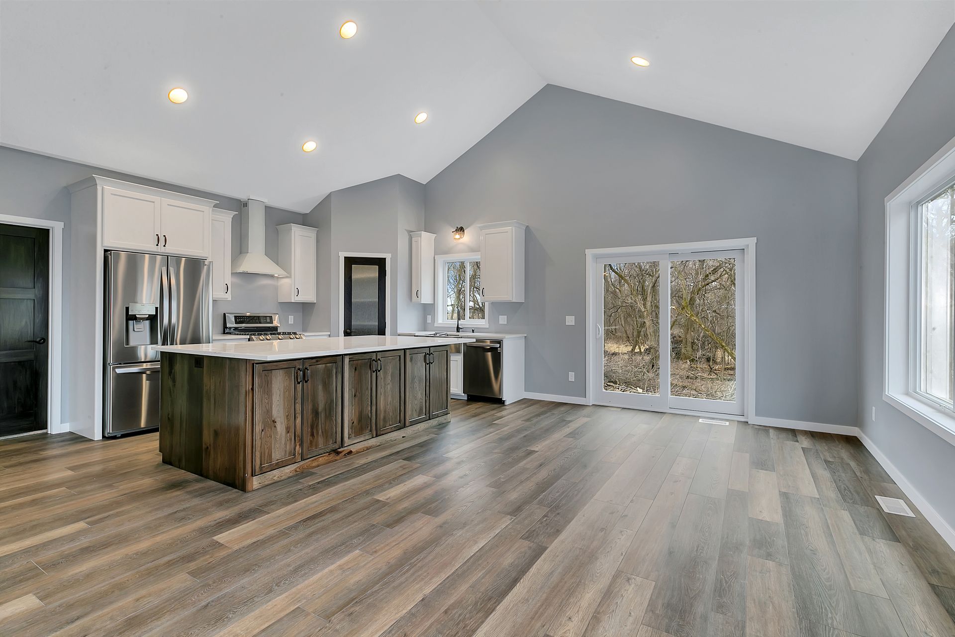 A kitchen with stainless steel appliances and a large island in the middle of the room.