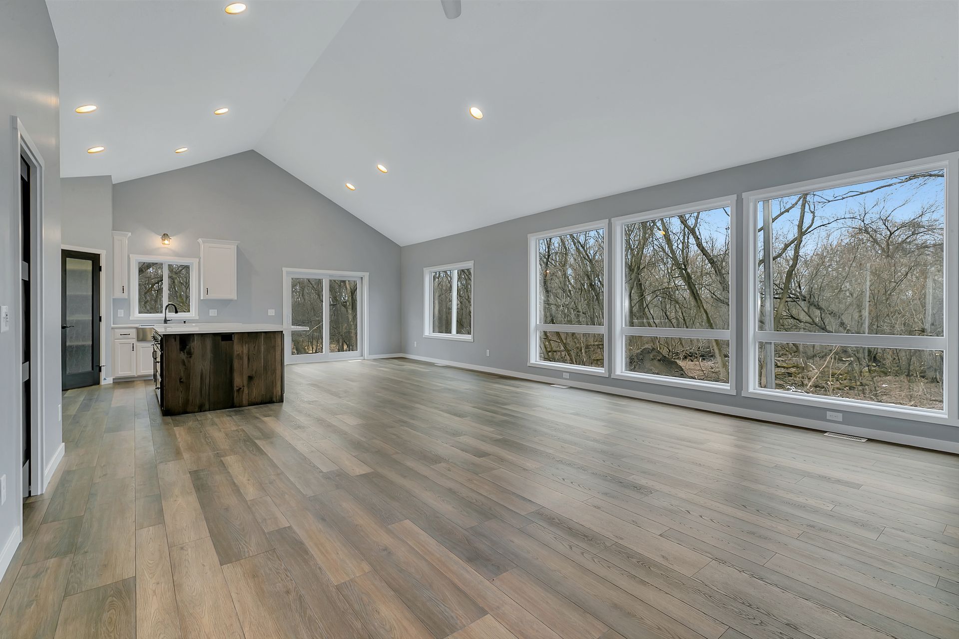 A large empty room with hardwood floors and lots of windows.