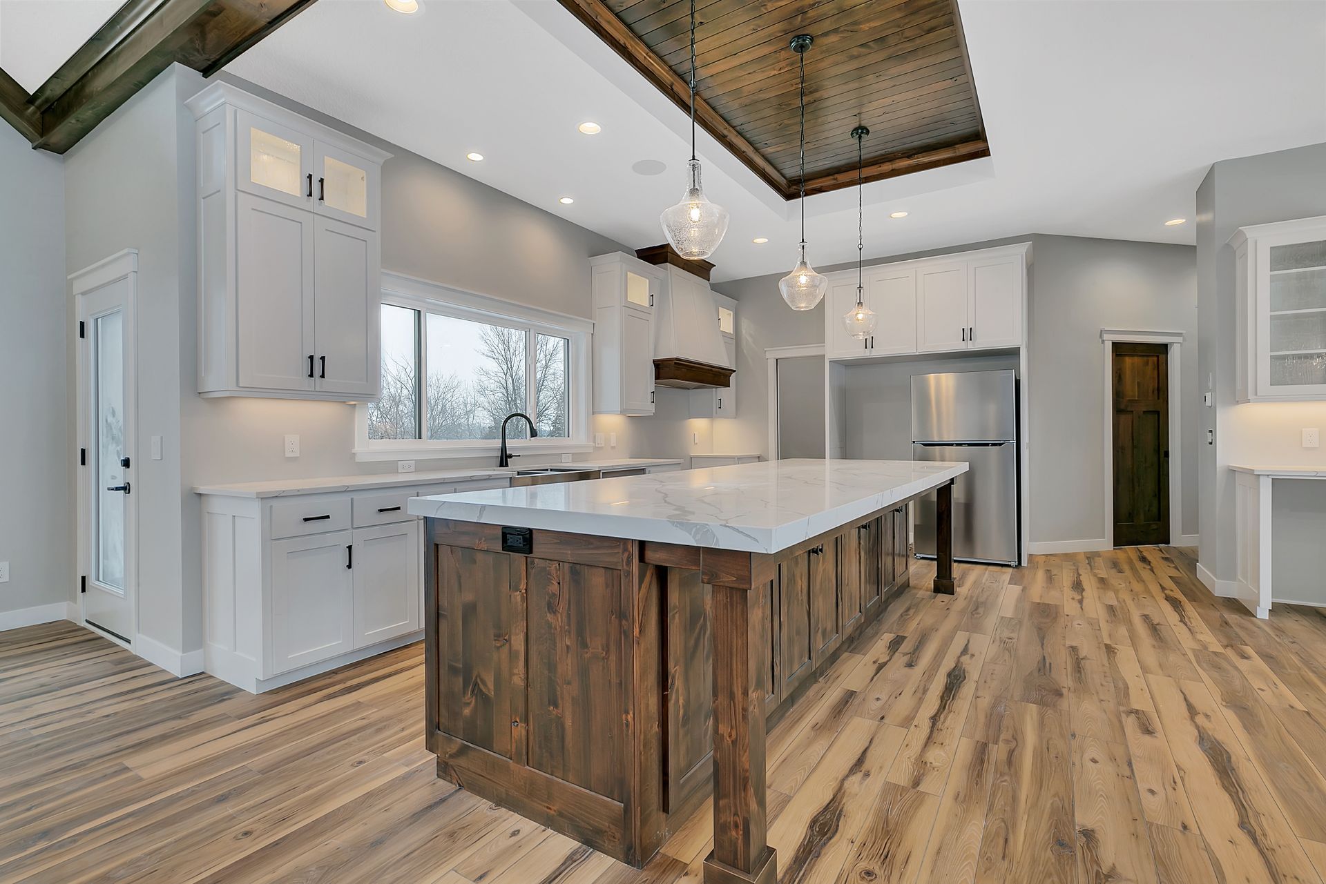 A kitchen with white cabinets and a large island in the middle.