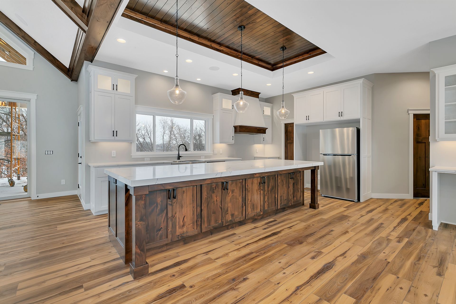 A kitchen with a large island in the middle and hardwood floors.