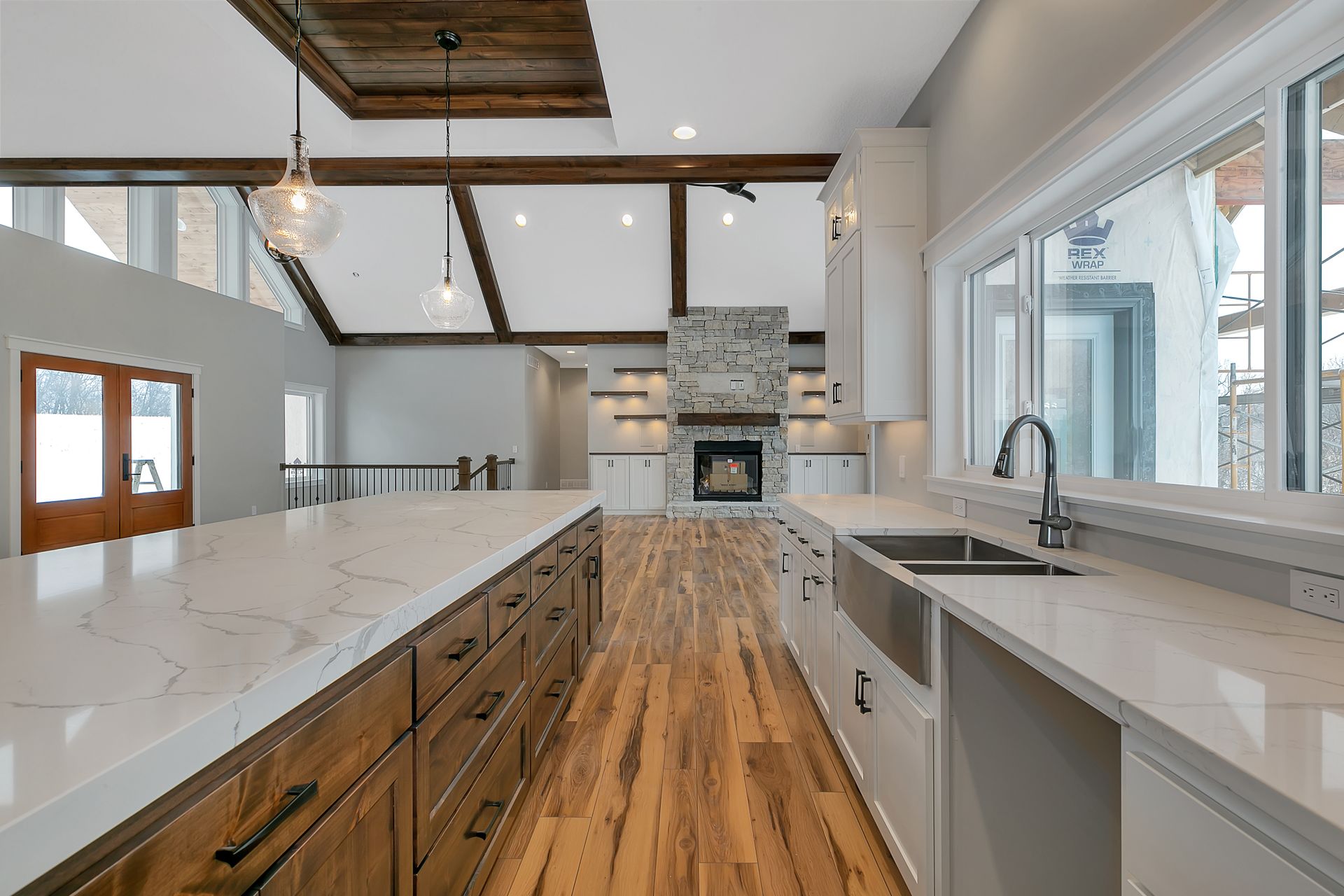 A kitchen with wooden cabinets , white counter tops , a sink , and a fireplace.