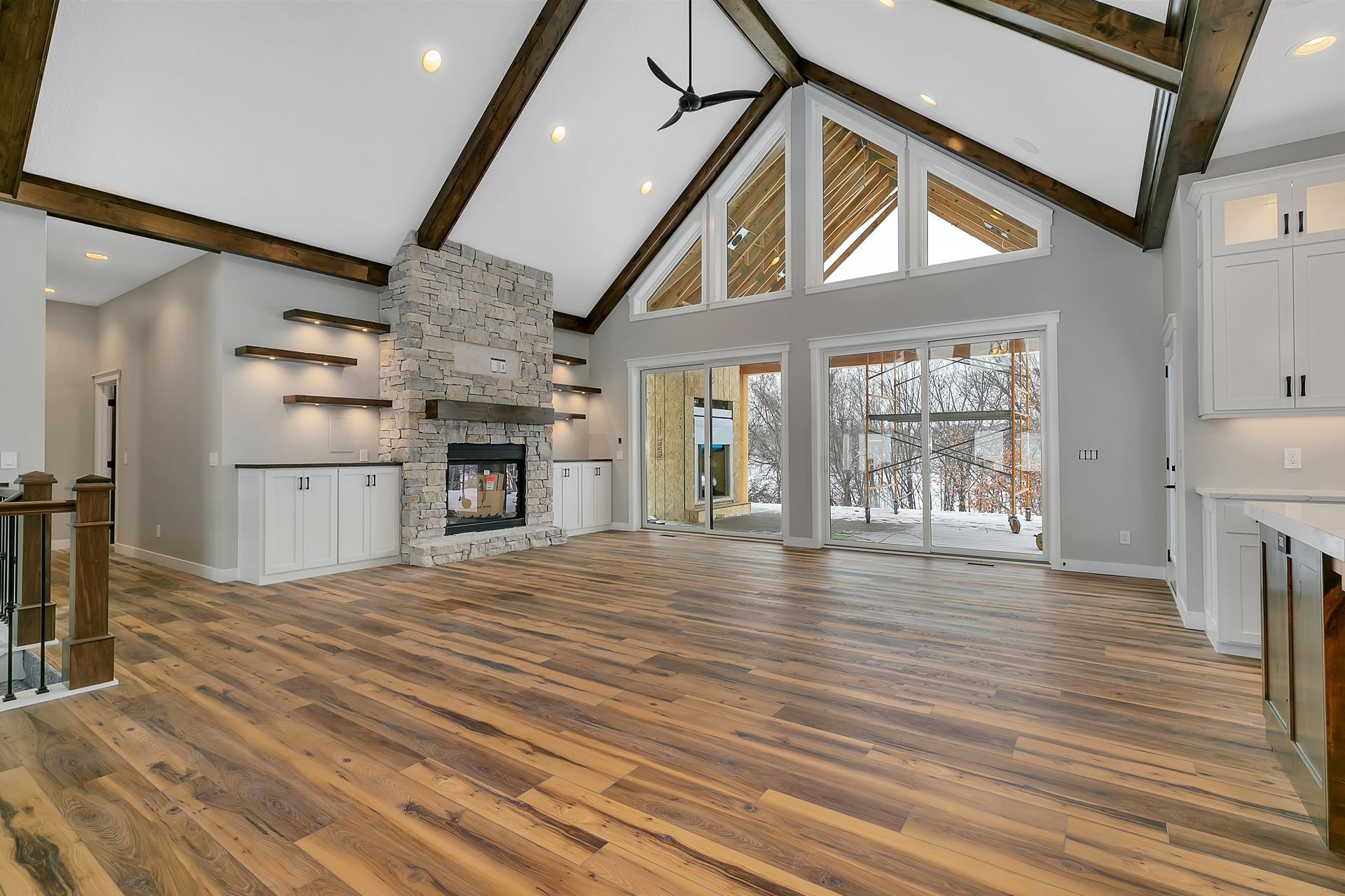 A large empty living room with hardwood floors and a fireplace.