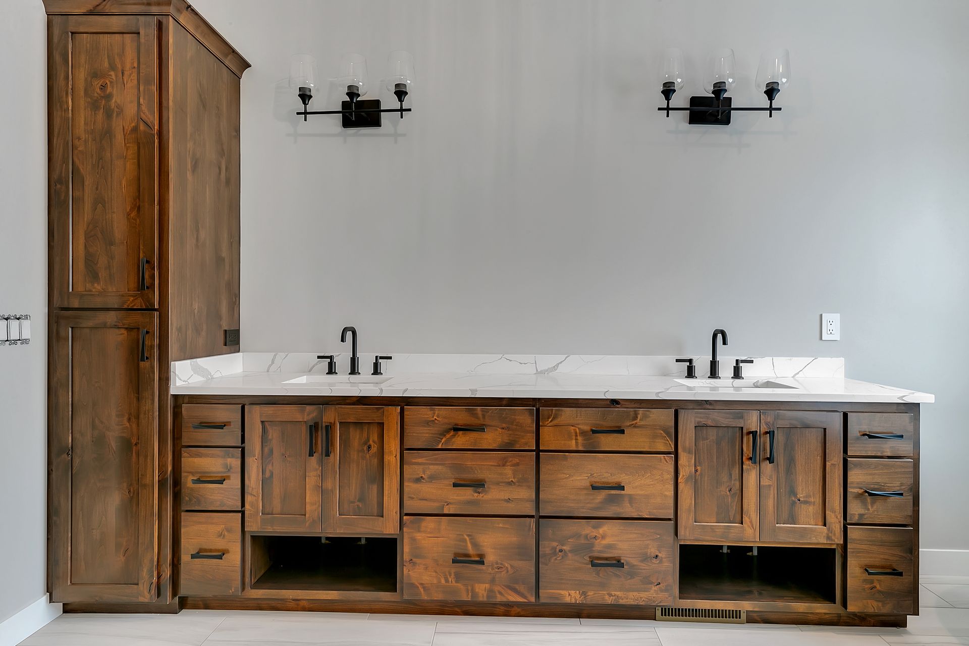 A bathroom with two sinks and wooden cabinets.