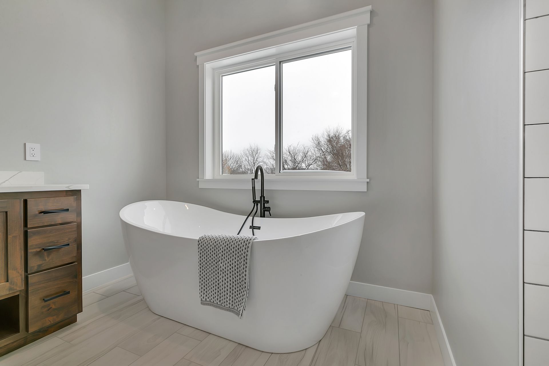 A bathroom with a bathtub and a window.