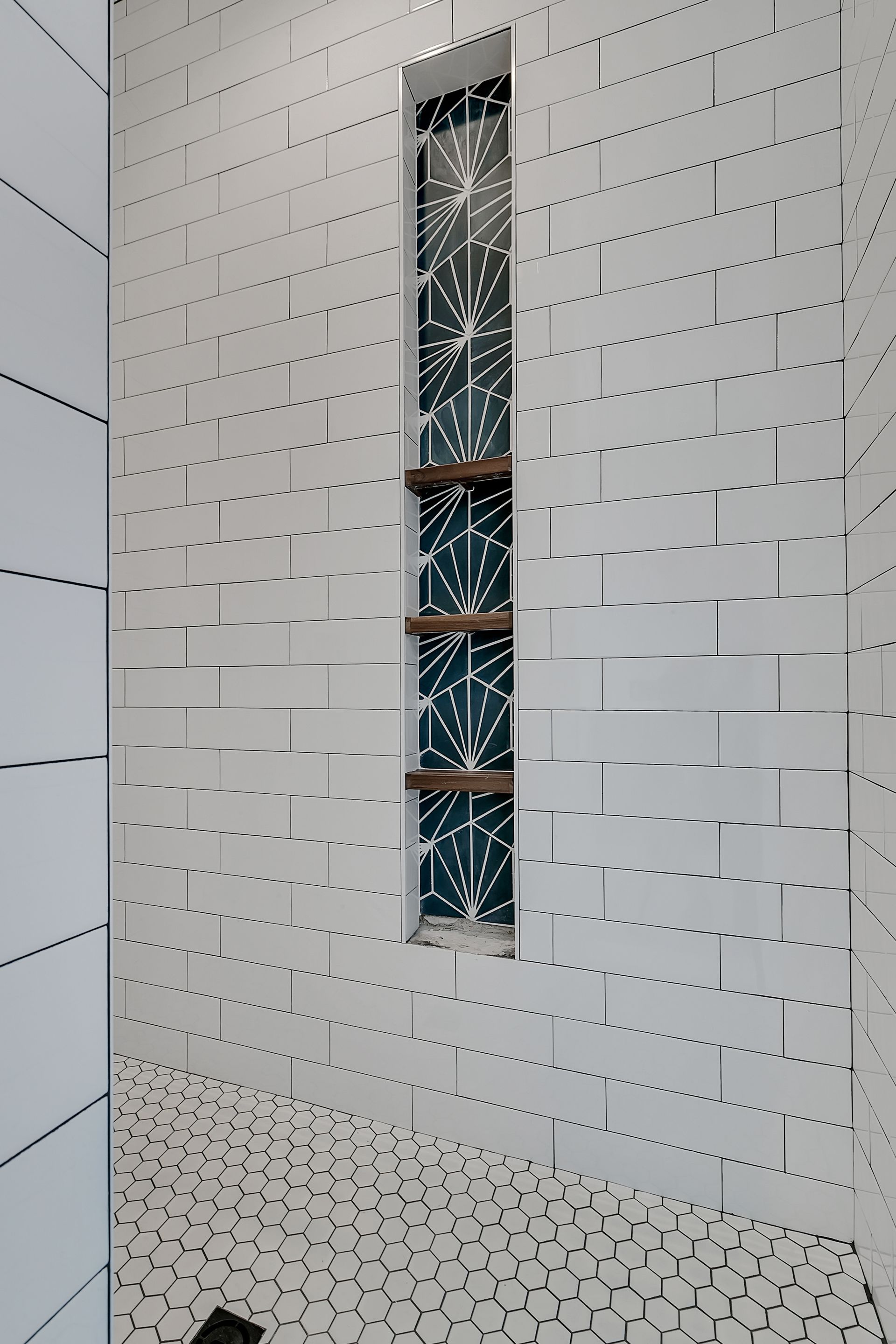 A shower with white tiles and a window in the wall