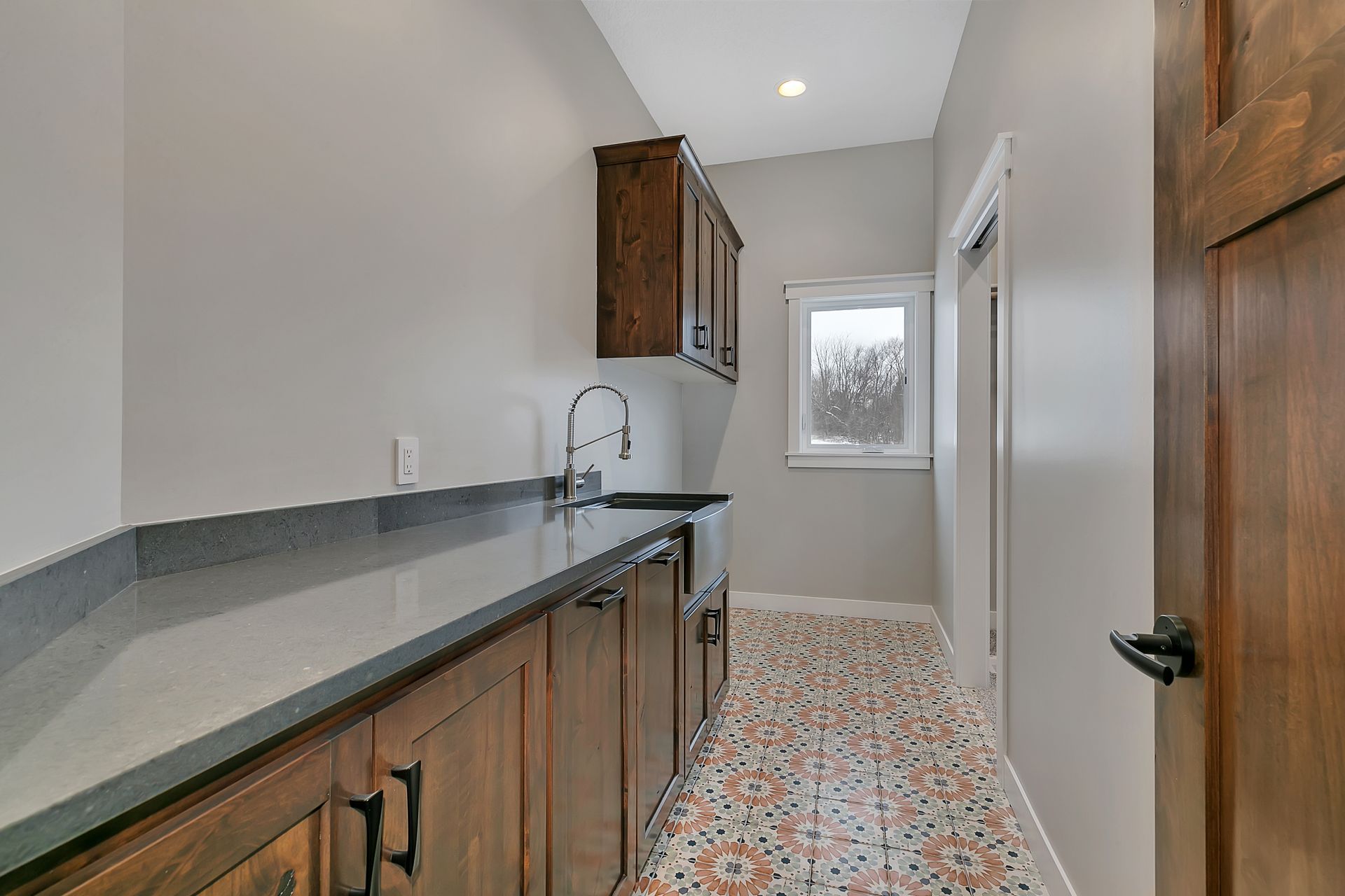 A kitchen with a sink , cabinets and a window.