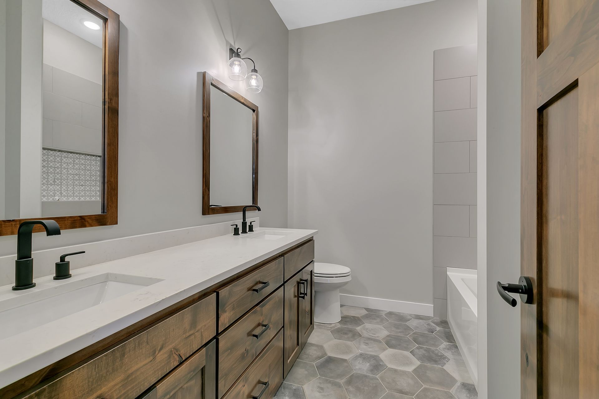 A bathroom with two sinks , a toilet , and a bathtub.