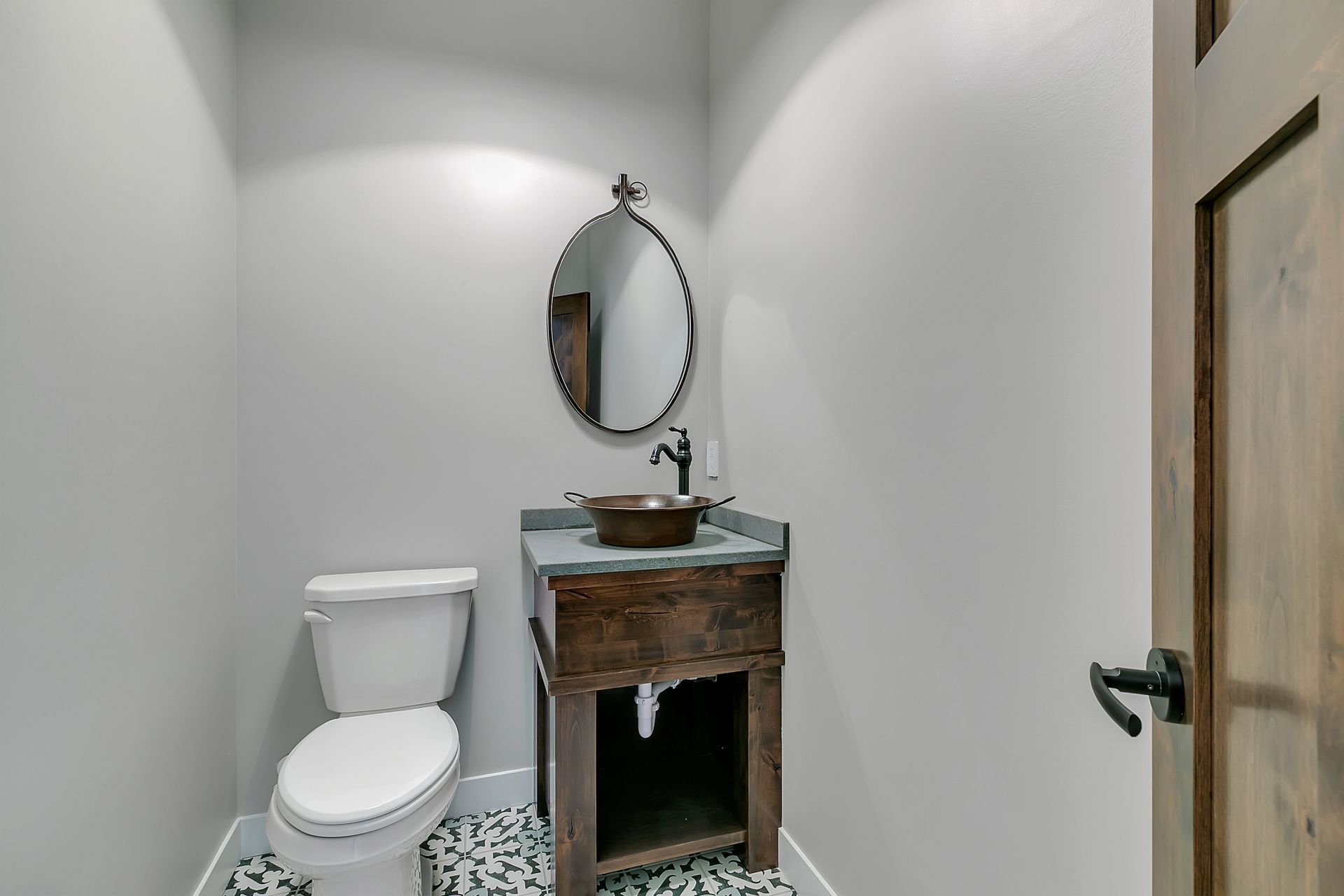 A bathroom with a toilet , sink and mirror.