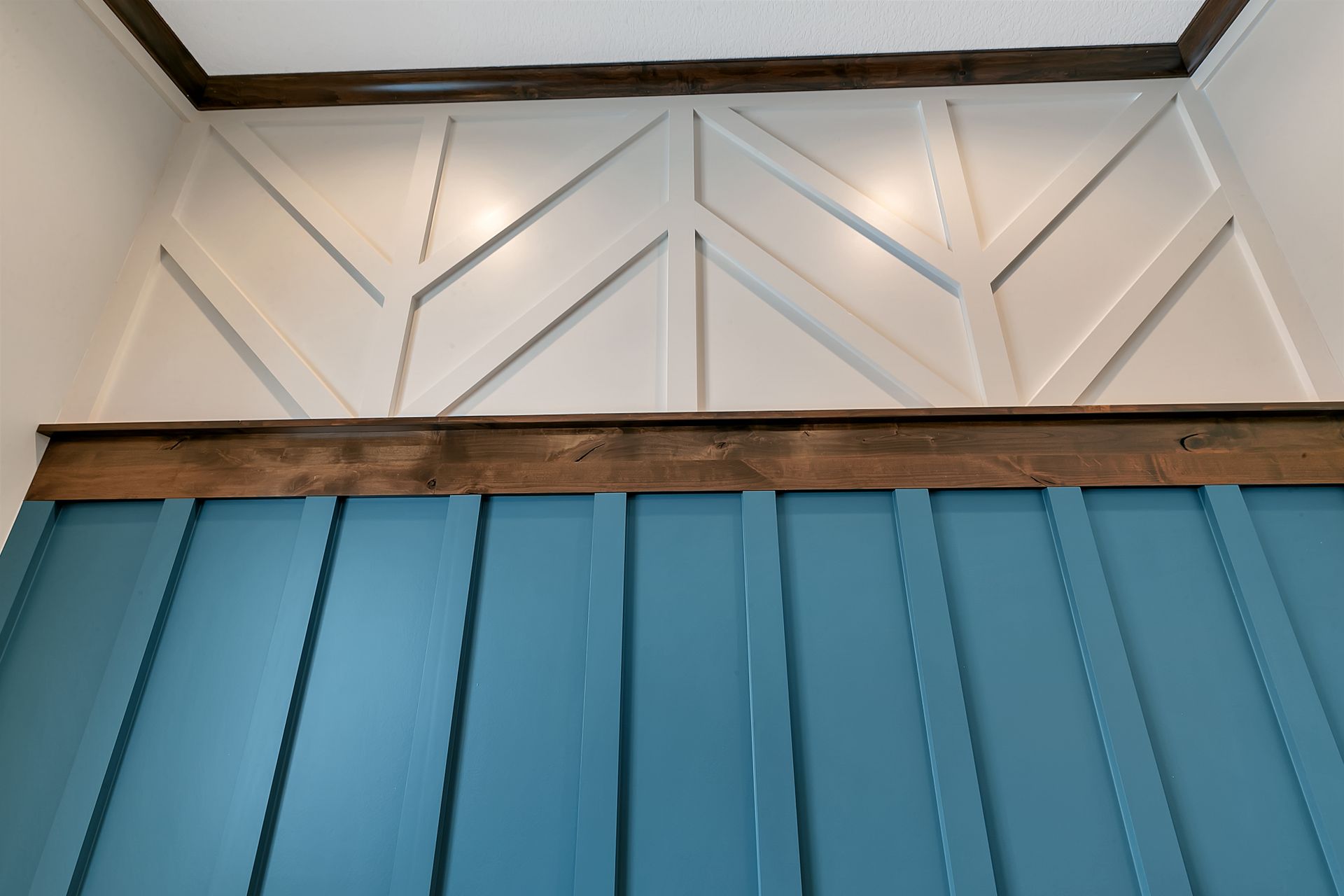 A blue wall with white trim and a wooden ceiling