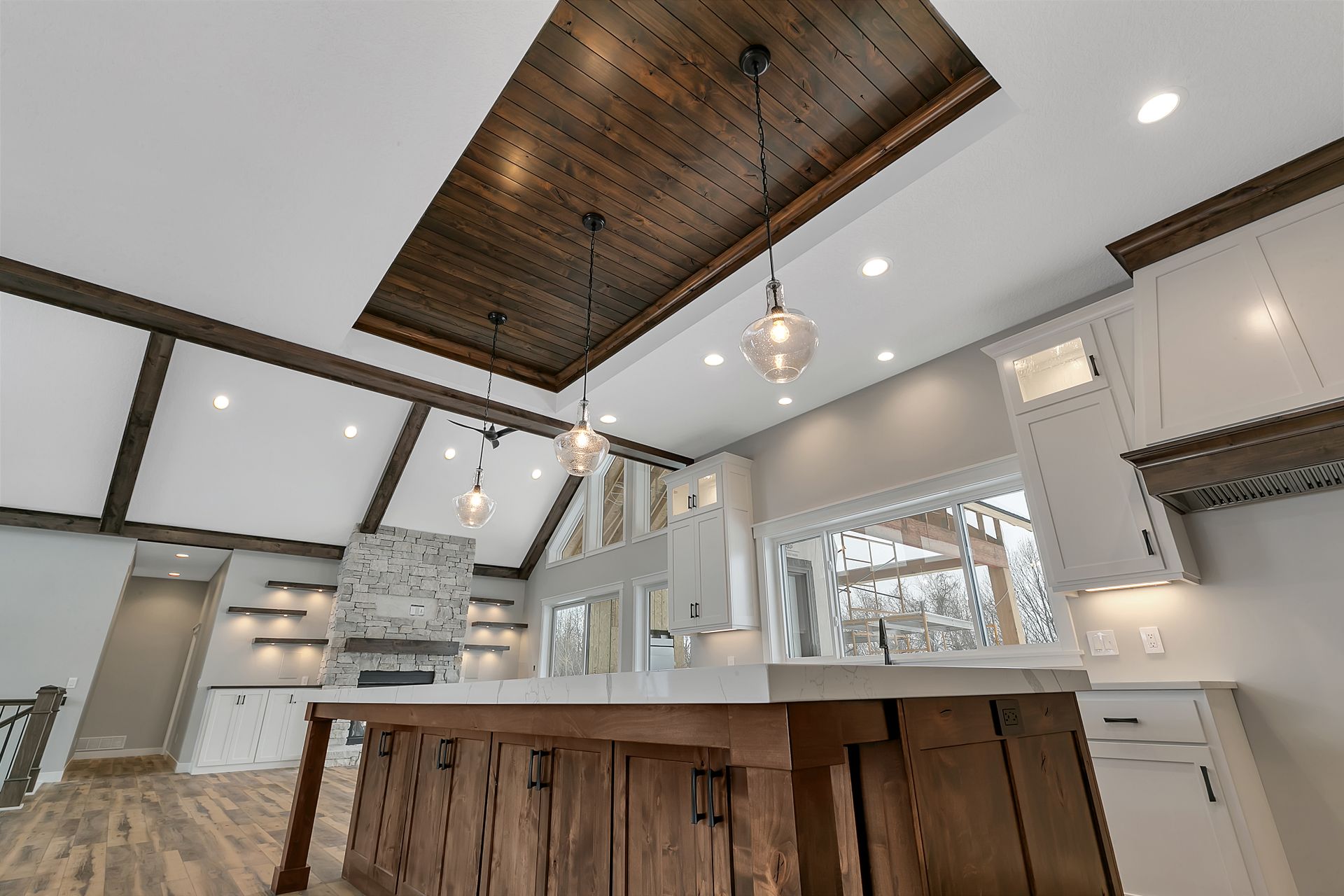 A kitchen with a large island and a wooden ceiling.