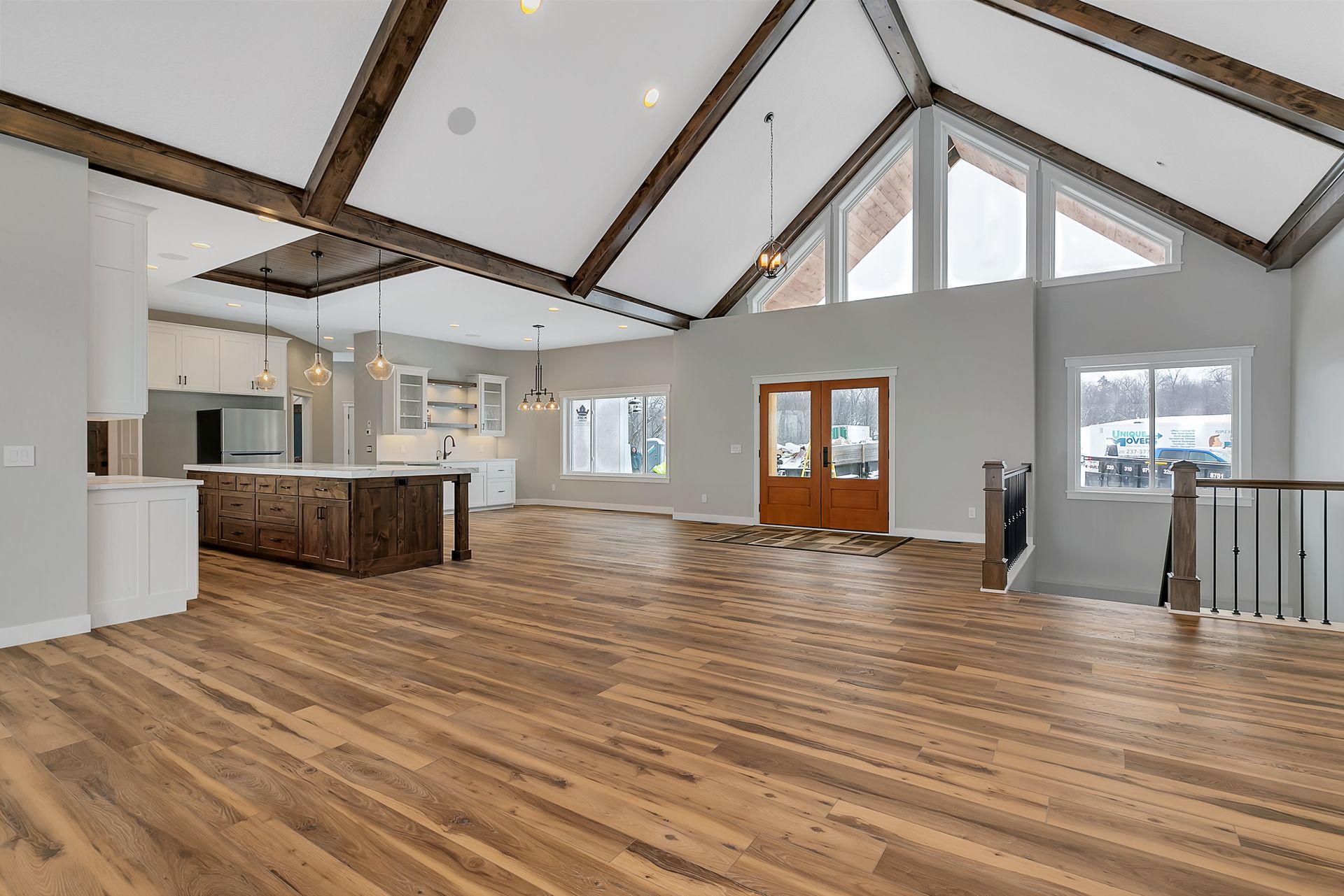A large empty room with hardwood floors and a vaulted ceiling.
