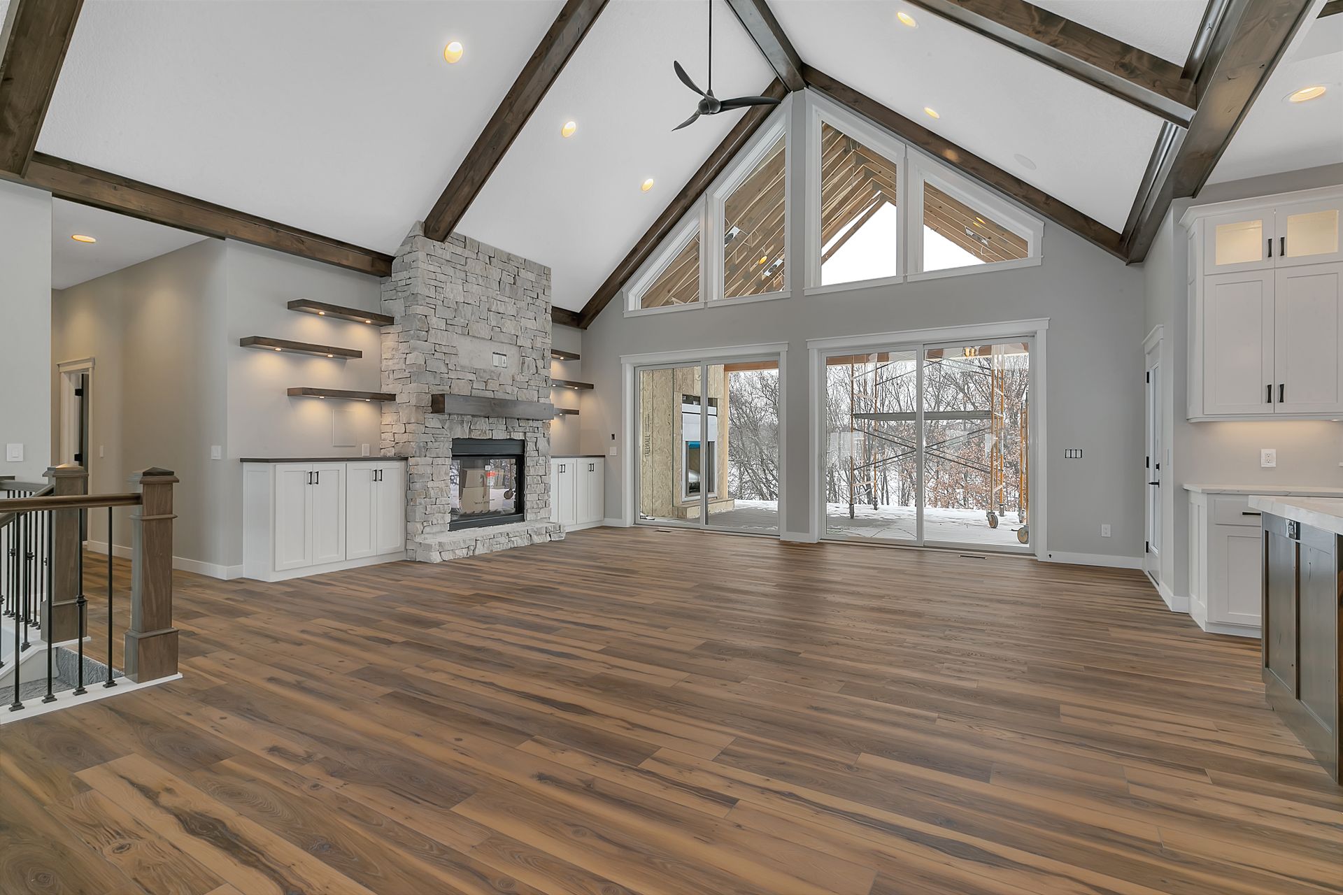 A large empty living room with hardwood floors and a fireplace.