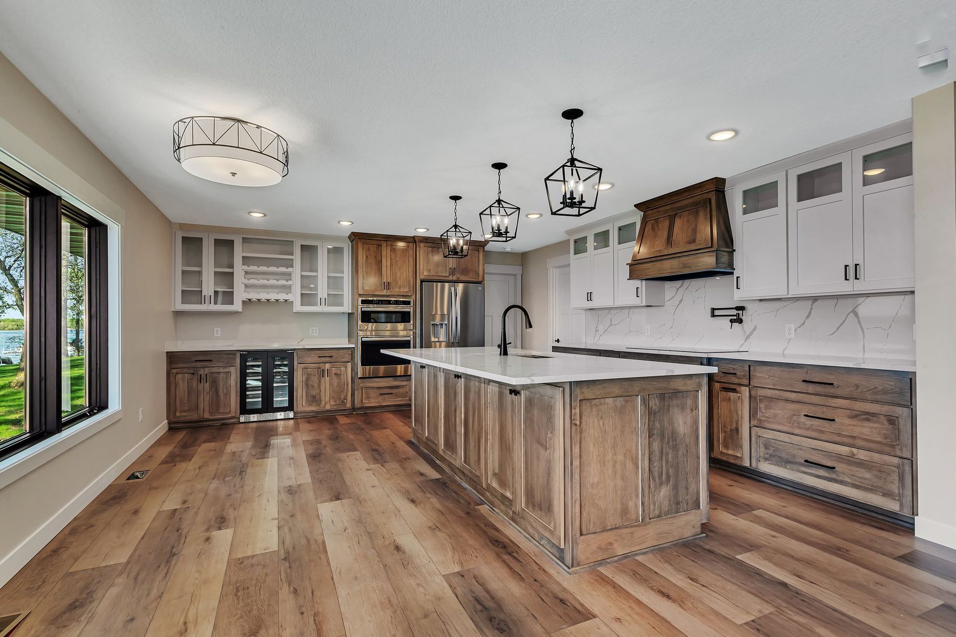 A kitchen with wooden cabinets and a large island in the middle.