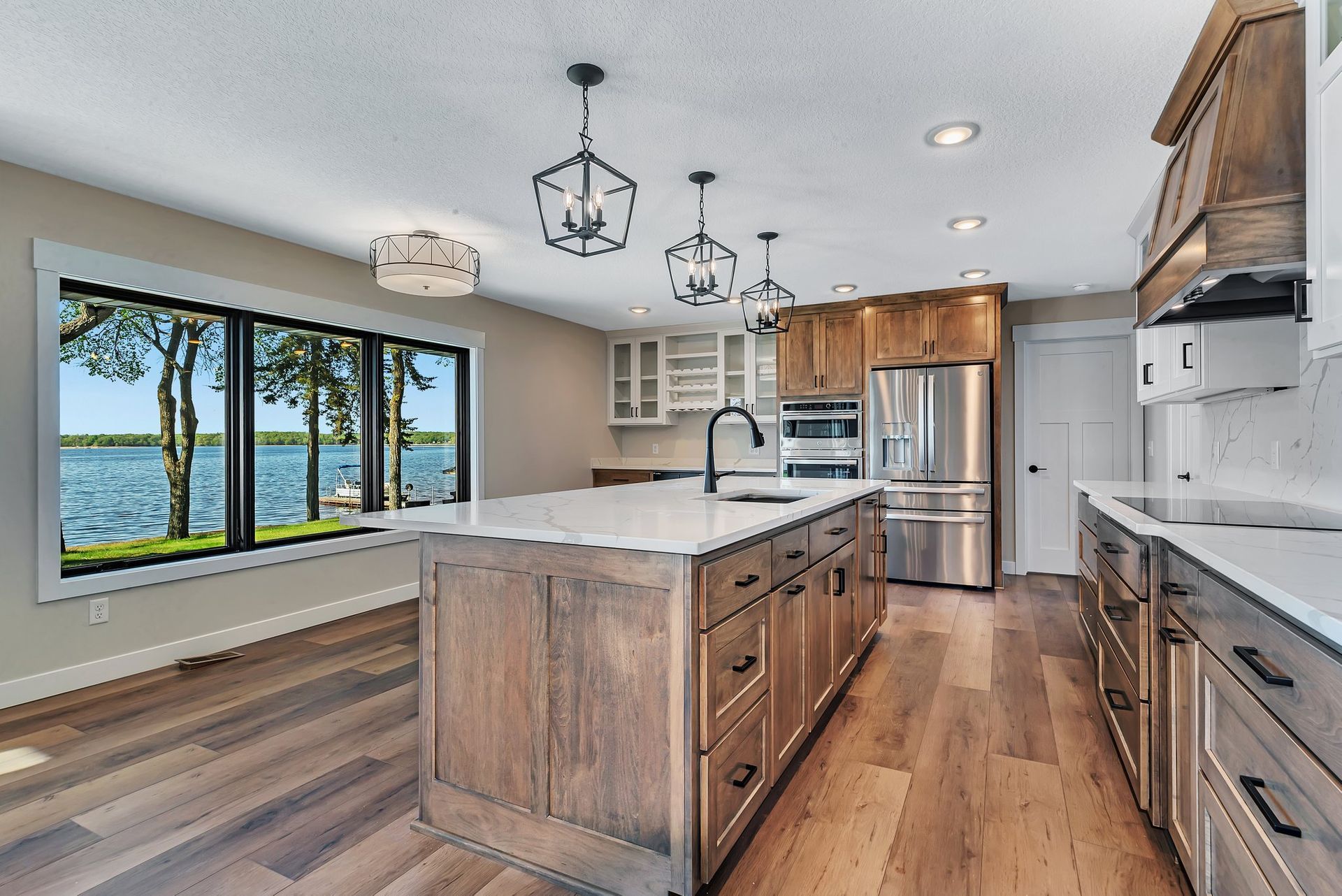 A kitchen with a large island in the middle and a view of a lake.