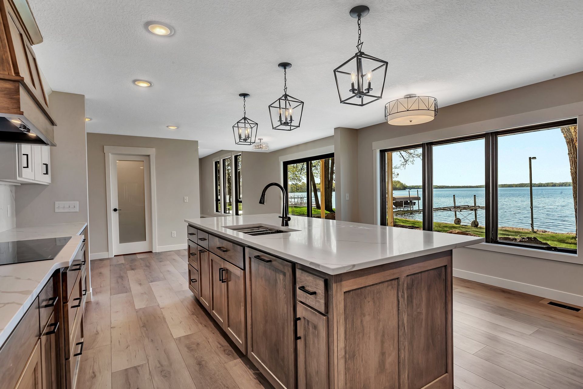A kitchen with a large island in the middle and a view of a lake.