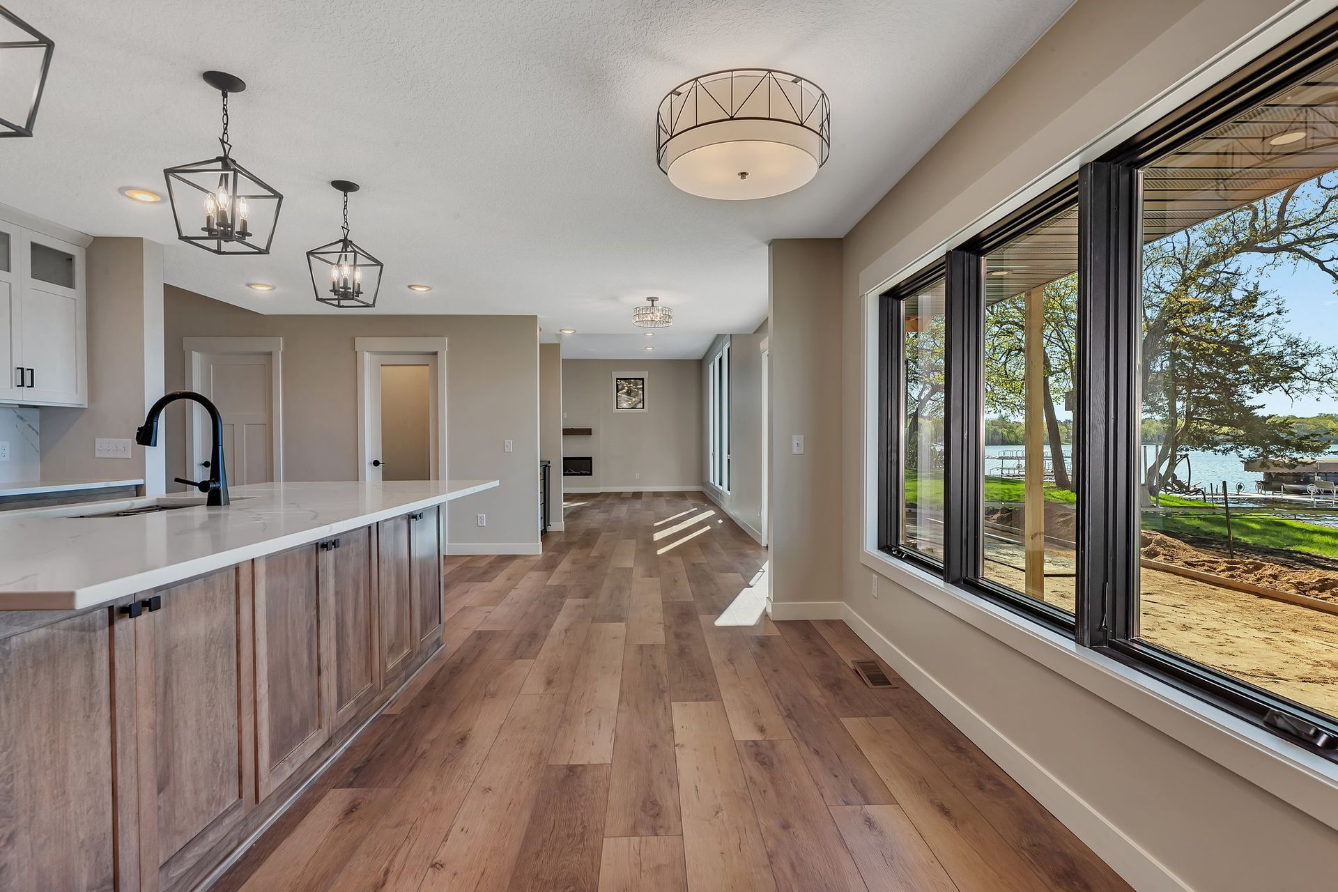 A kitchen with a lot of windows and hardwood floors.