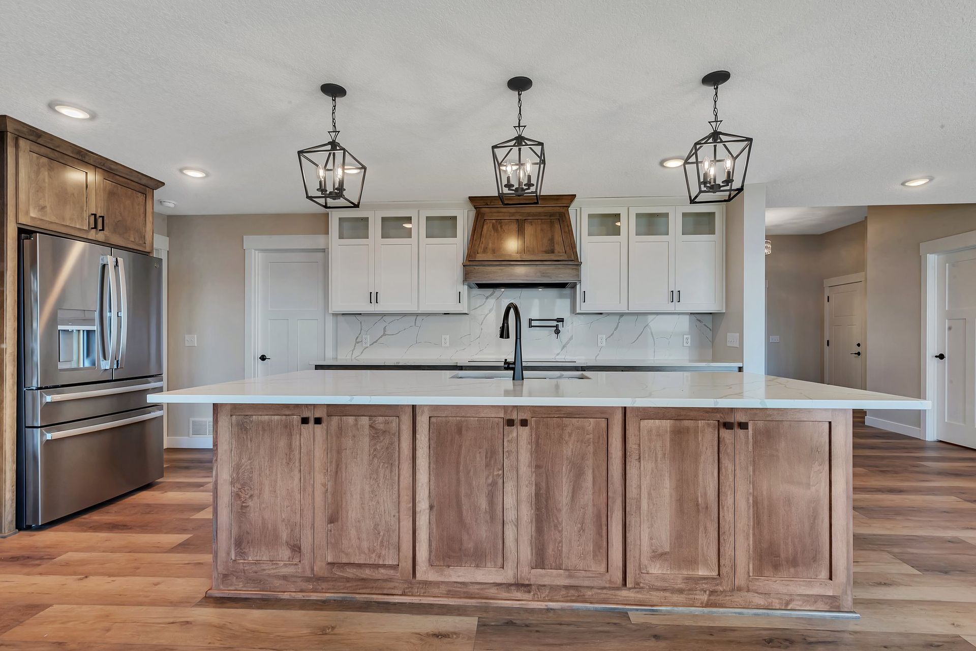 A kitchen with wooden cabinets , stainless steel appliances , and a large island.