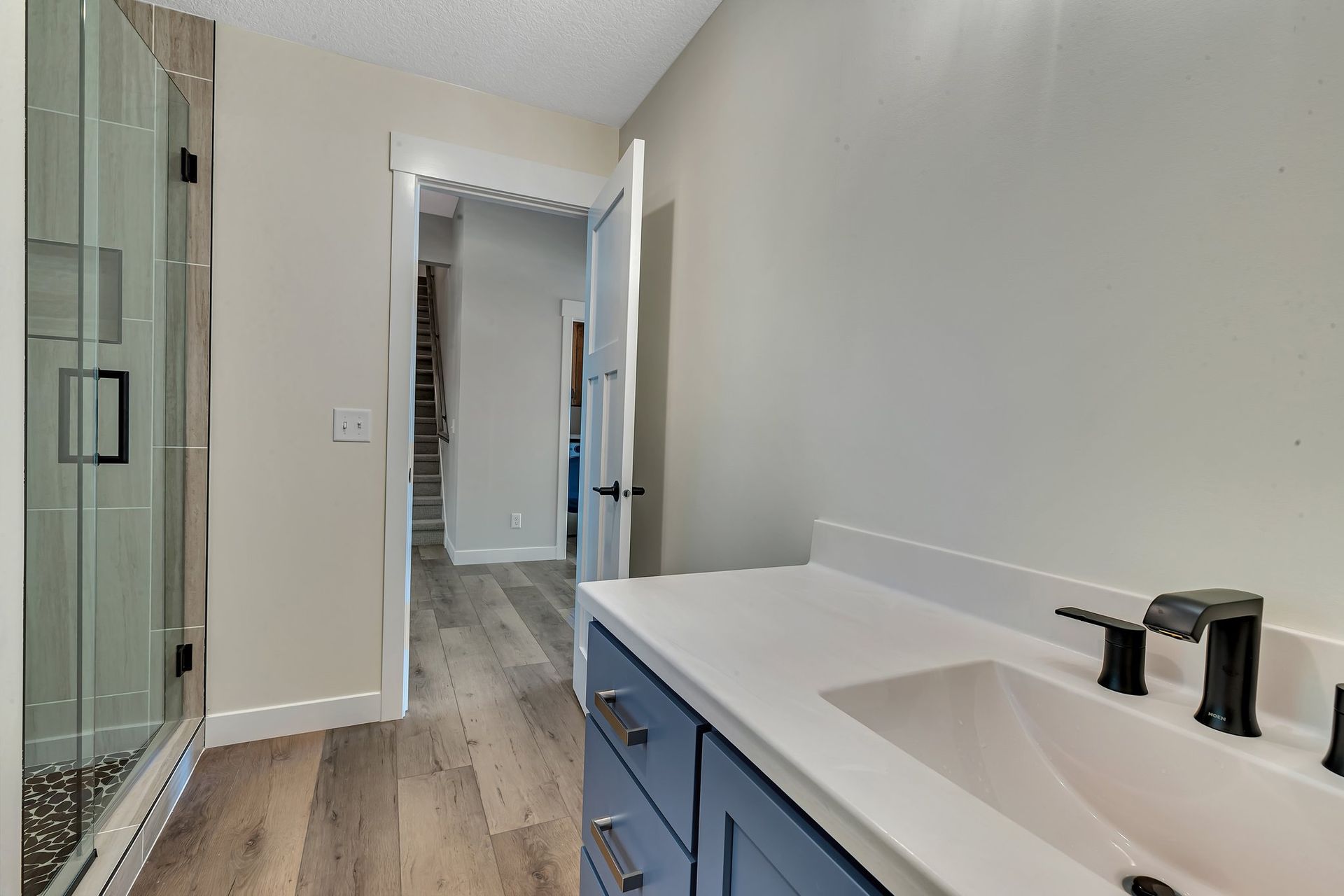 A bathroom with a sink and a walk in shower.